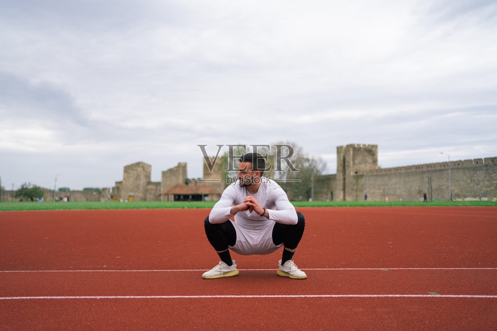 Young athlete man doing stretches exercise before running照片摄影图片