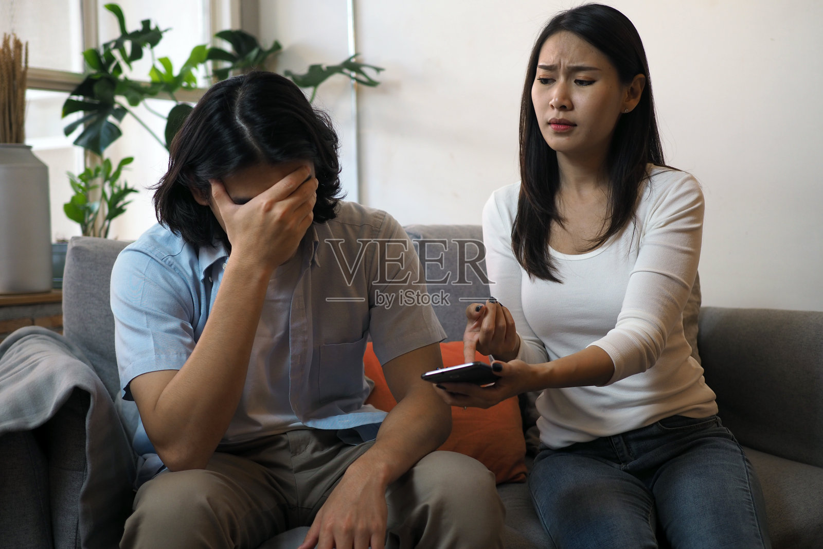 The husband expressed annoyance to his wife who was checking the phone.照片摄影图片