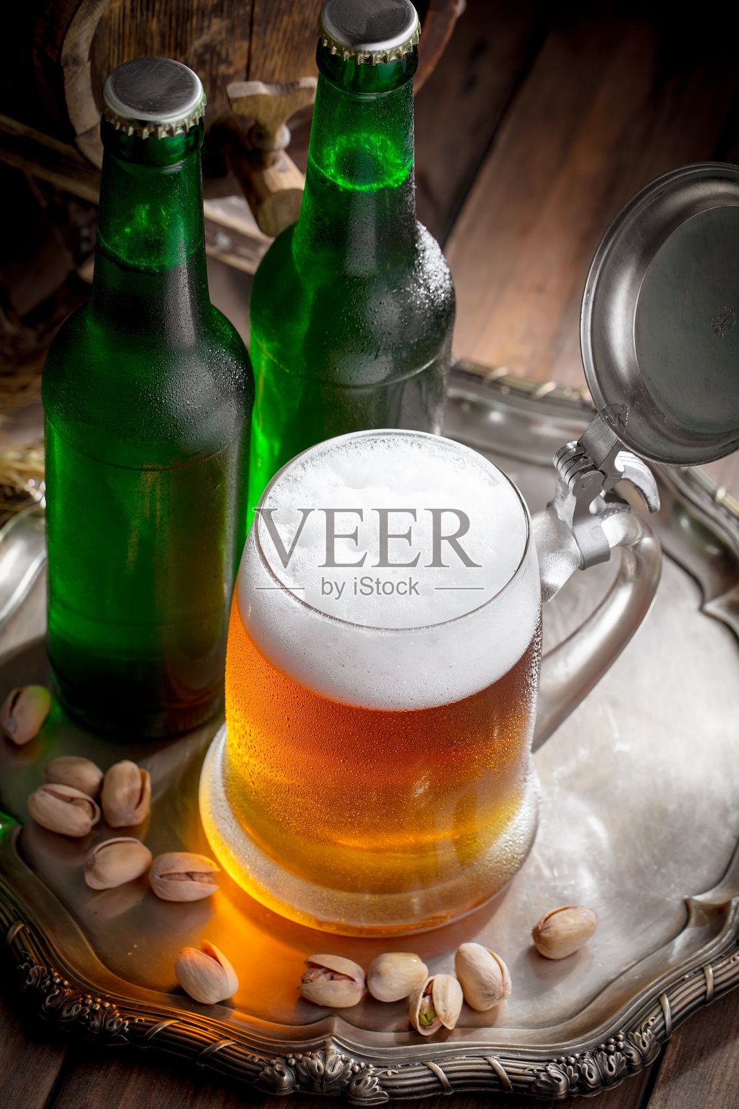 木背景上的玻璃杯里装着淡啤酒。照片摄影图片