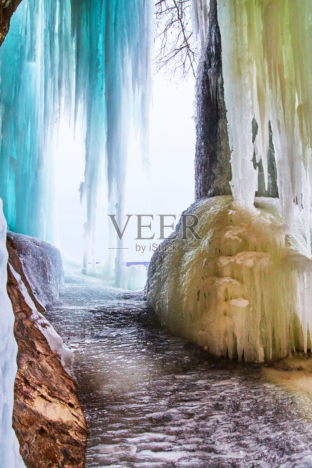 洞穴中美丽的冰冻冰和蓝色冰柱照片摄影图片