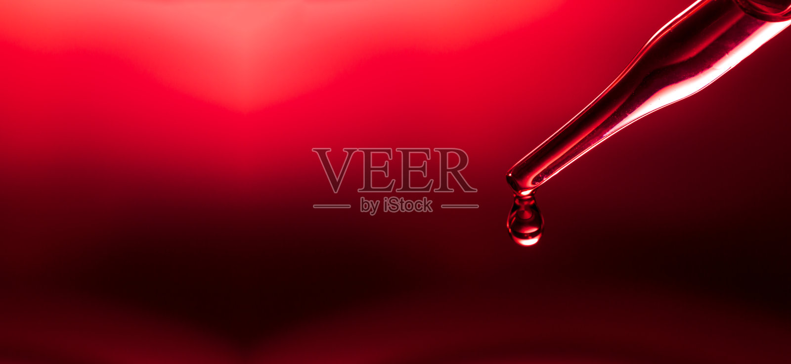 宏观科学实验移液器表面，红色背景下，化学液滴将油注入三个培养皿中的透明液体中。抽象护肤化妆品概念。照片摄影图片