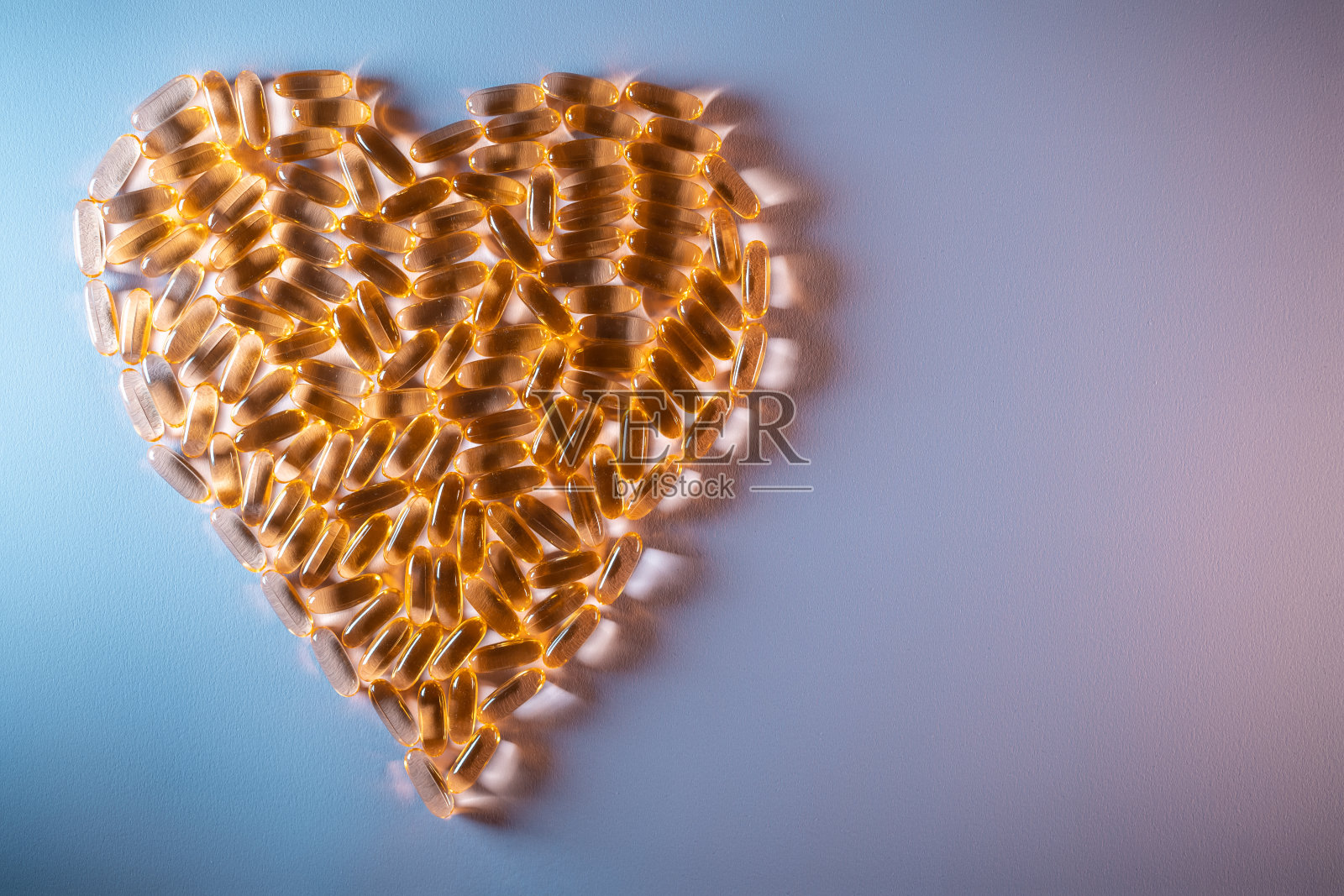 金色鱼油胶囊欧米茄3维生素心形紫色背景照片摄影图片