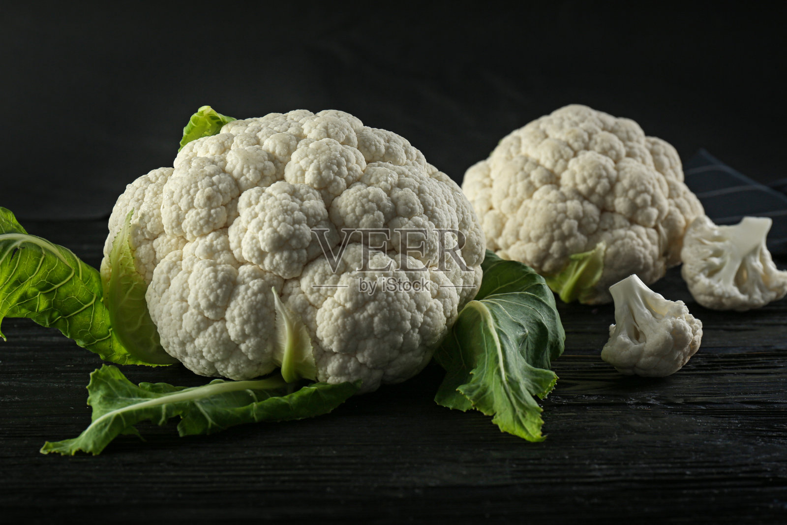 新鲜的整棵花椰菜放在黑色的木桌上照片摄影图片