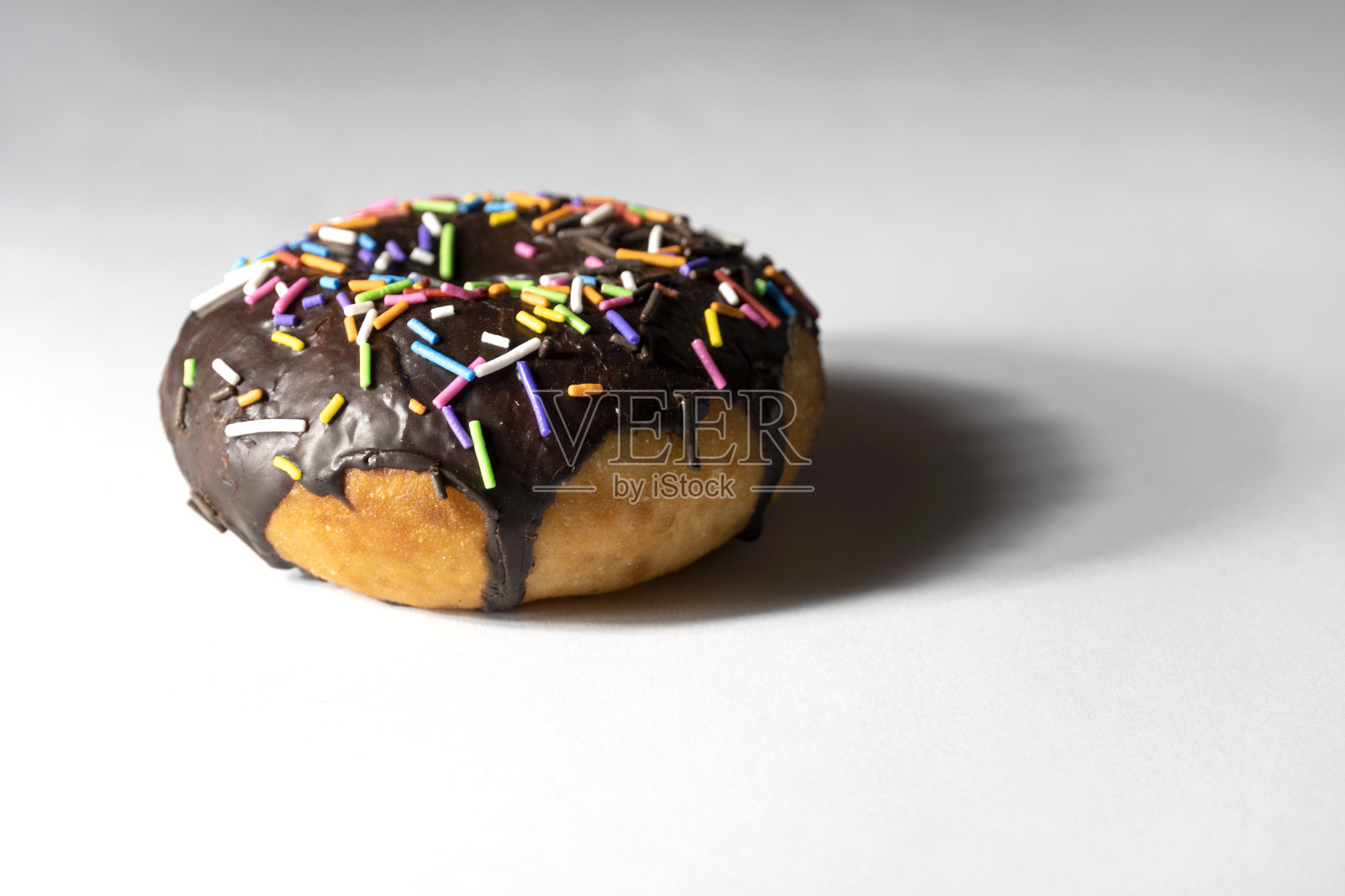 白色背景上的彩色甜甜圈。照片摄影图片