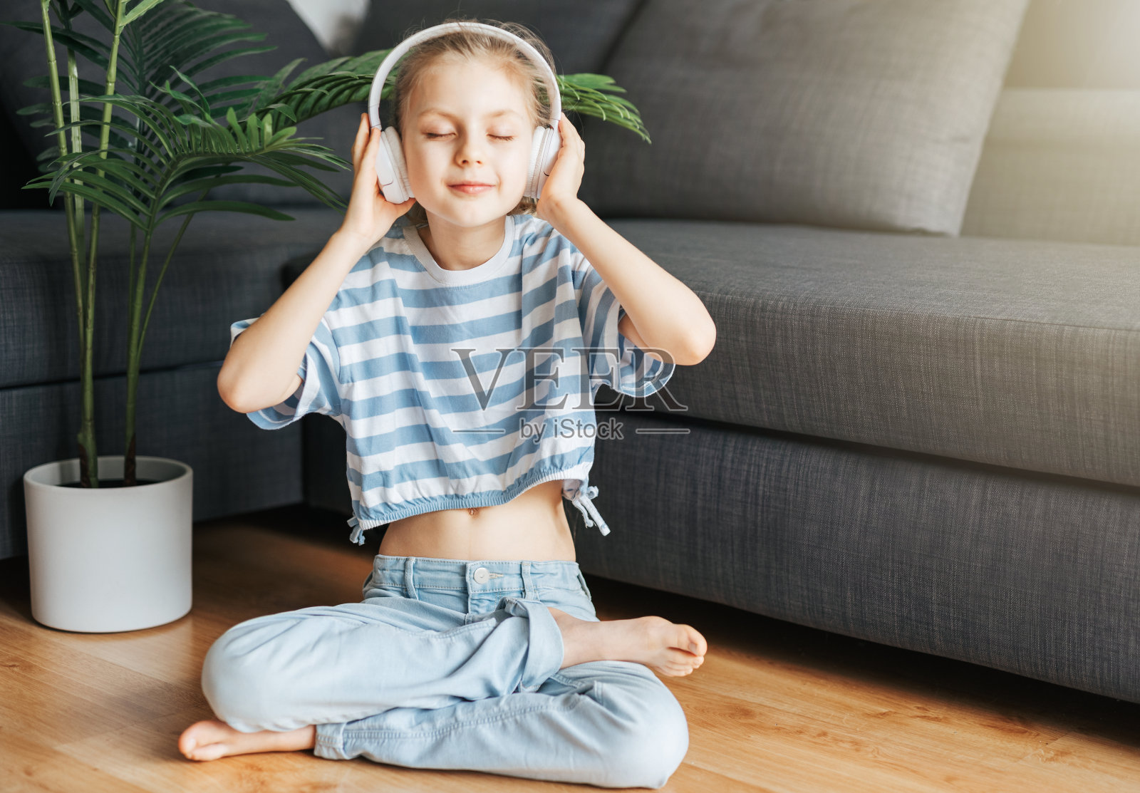 可爱的小女孩戴着耳机听音乐照片摄影图片