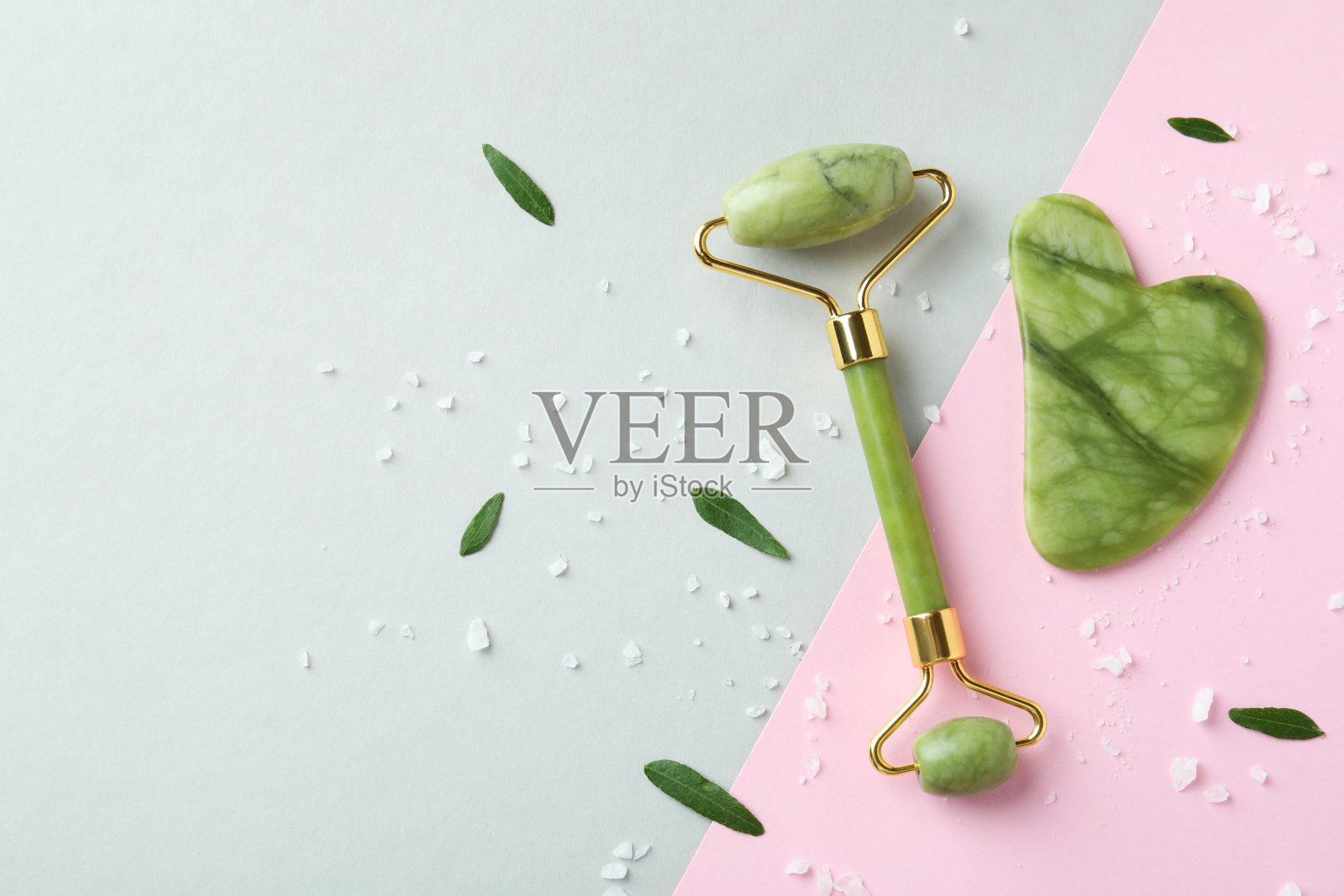 以双色调为背景，以脸辊和刮痧为护肤理念照片摄影图片