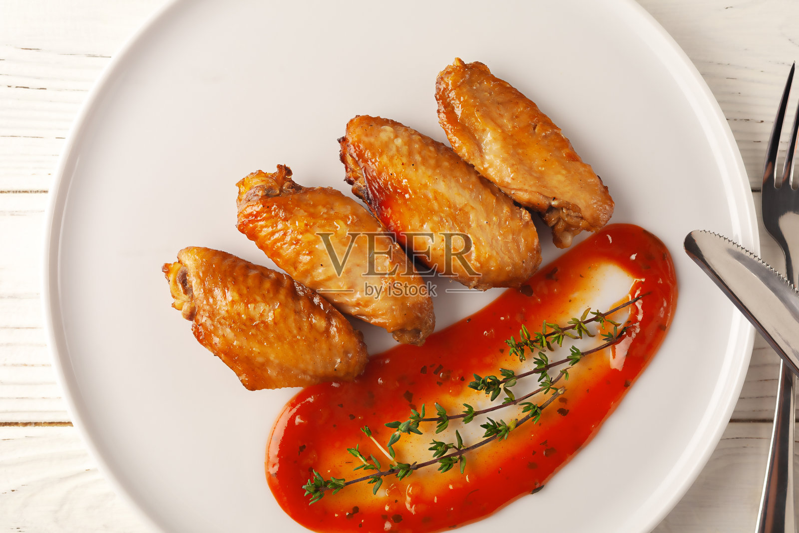 白底烤辣鸡翅配番茄酱。照片摄影图片
