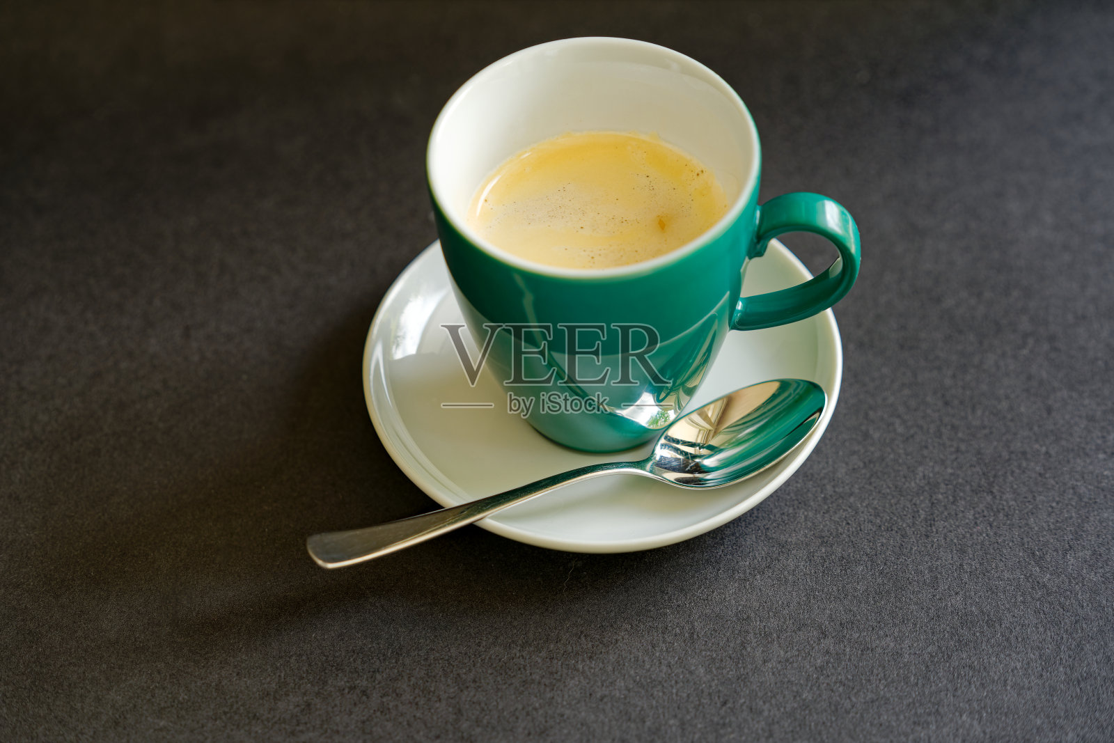 用茶匙和茶托装满的咖啡杯。照片摄影图片