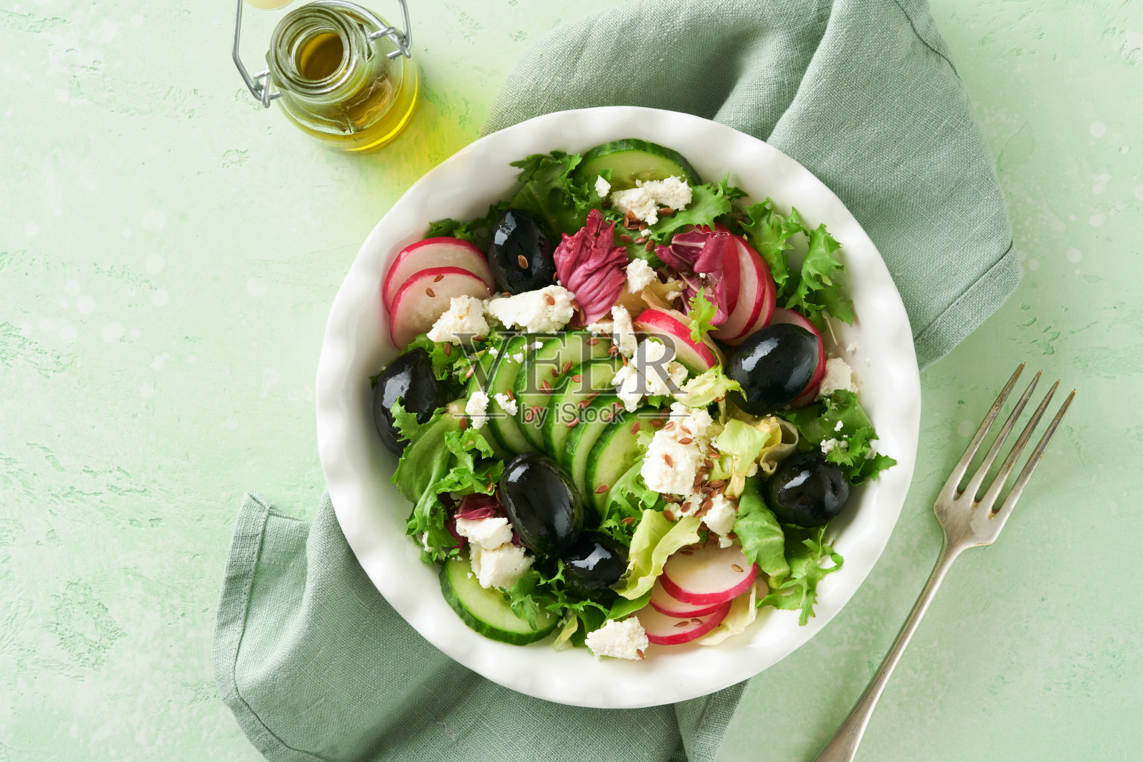 生菜沙拉，黄瓜沙拉，萝卜沙拉配干酪和亚麻籽橄榄油沙拉。健康的减肥食品。饮食菜单和均衡饮食。前视图。照片摄影图片