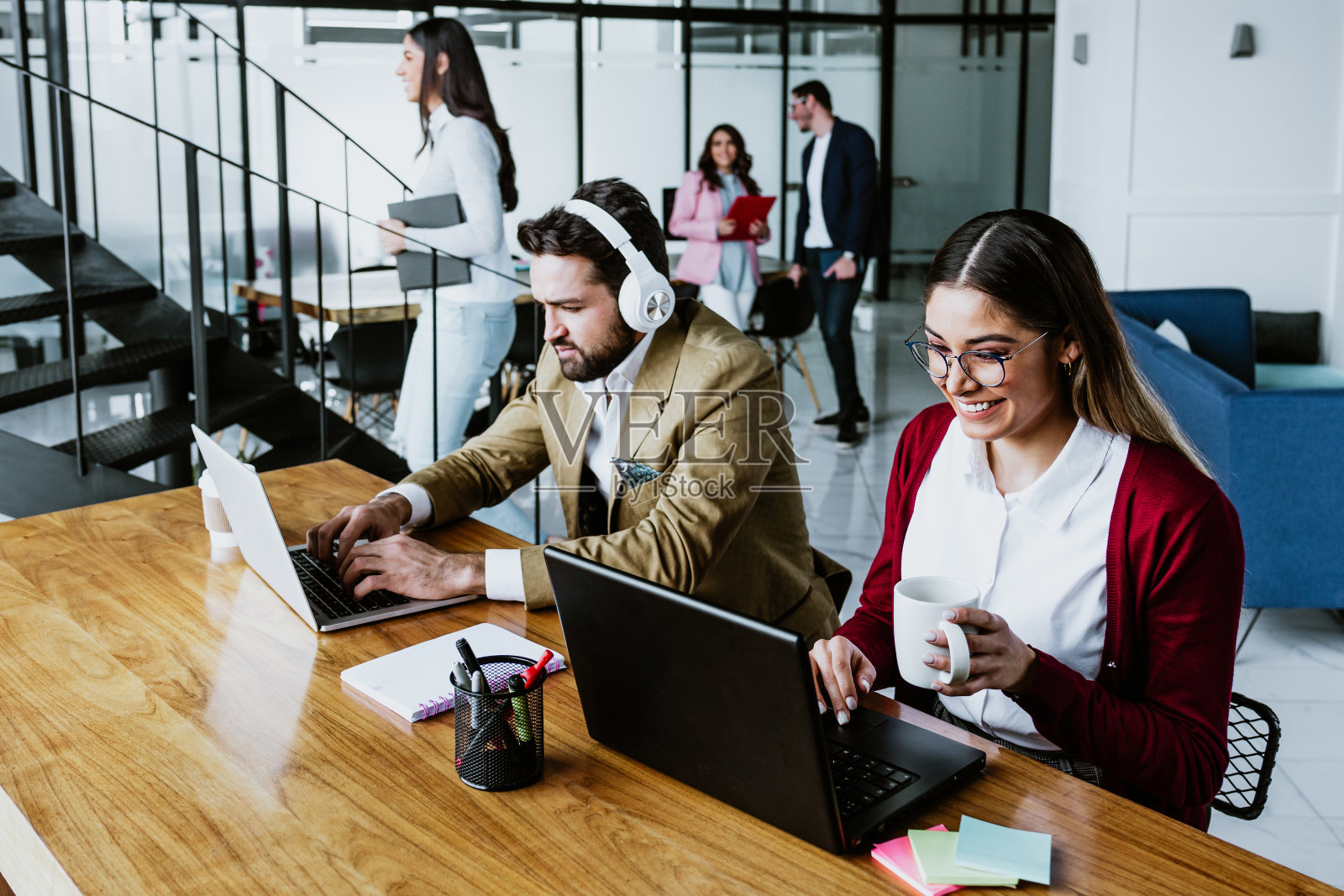 年轻的拉丁夫妇在墨西哥的办公室用笔记本电脑工作，拉丁美洲的拉丁裔团队合作照片摄影图片