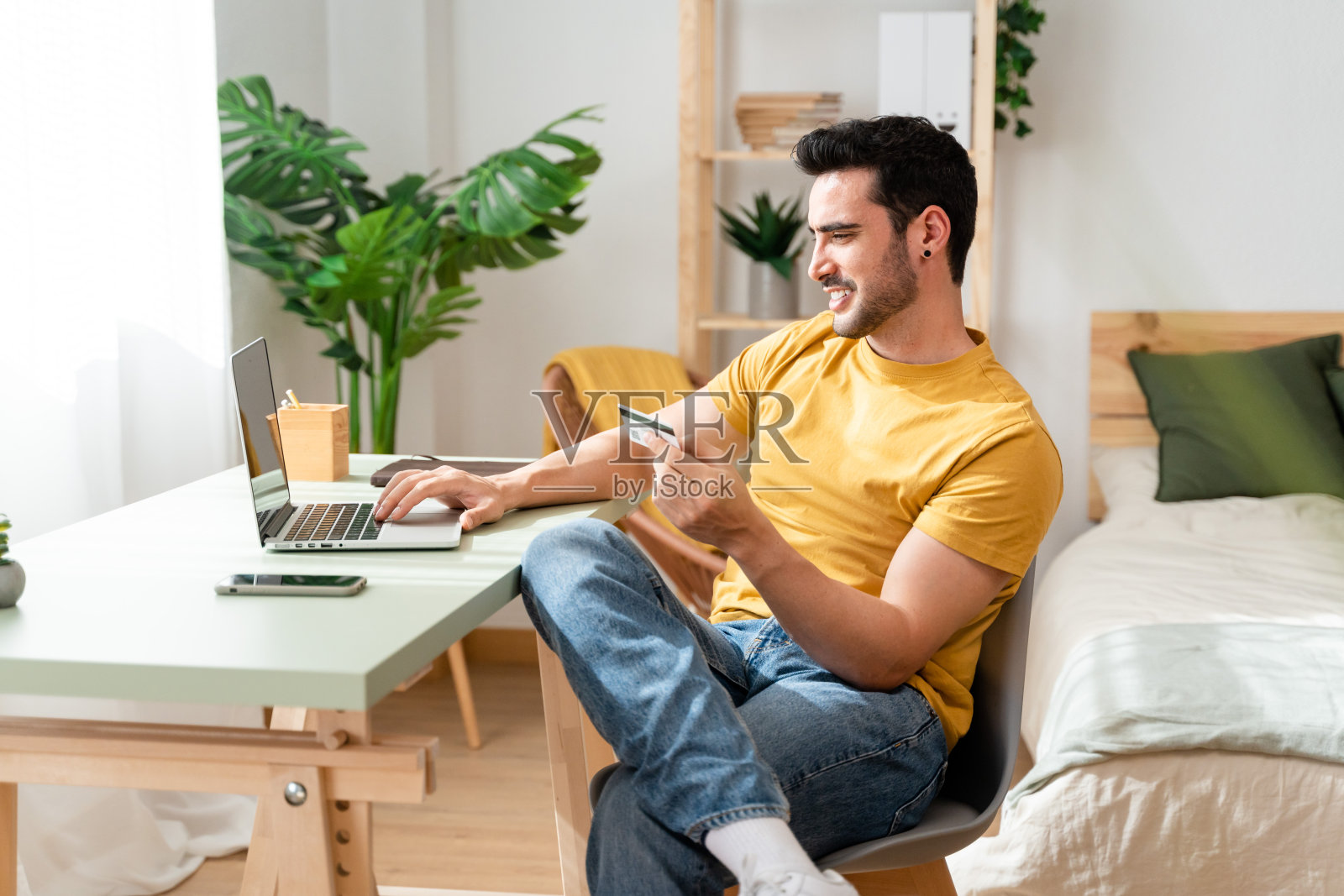 一个人在家里用笔记本电脑上网购物。照片摄影图片