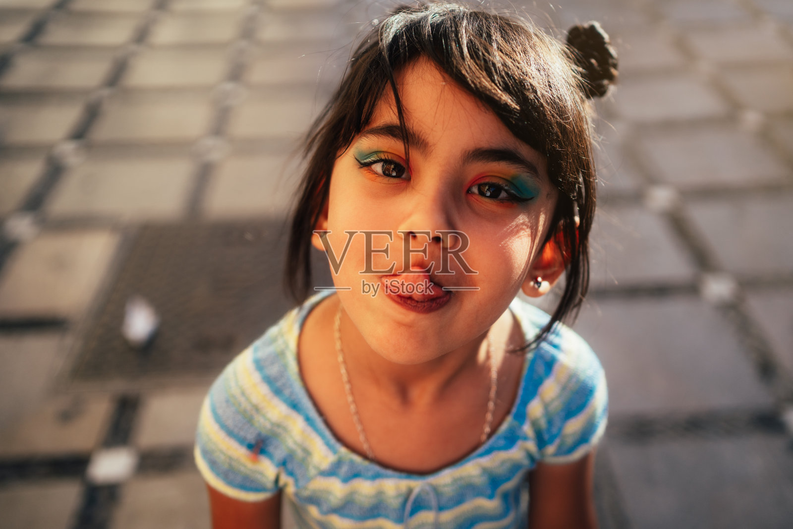 女孩一边看镜头一边吐舌头照片摄影图片