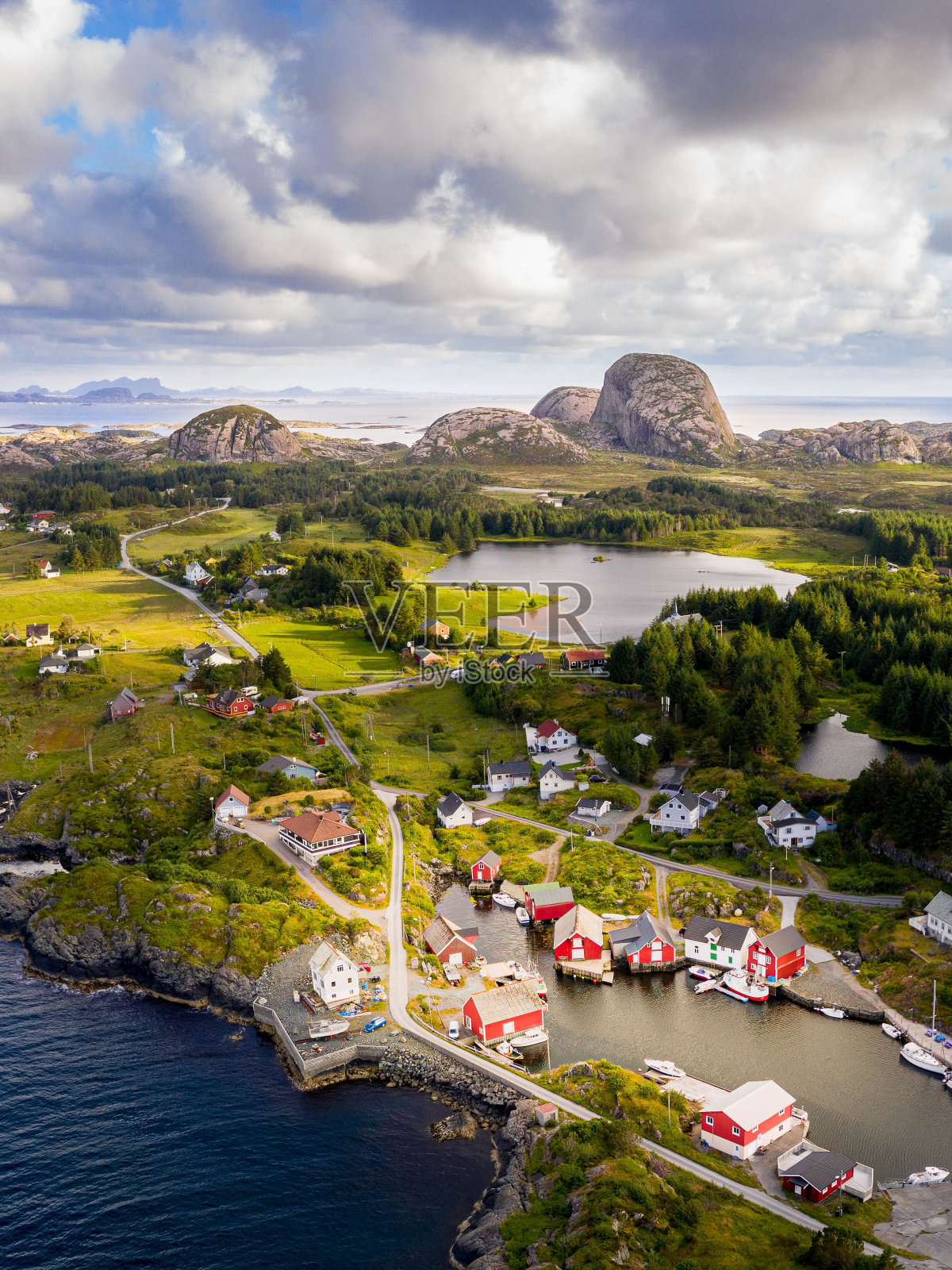 鸟瞰一个被绿色植物和湖泊包围的沿海村庄照片摄影图片