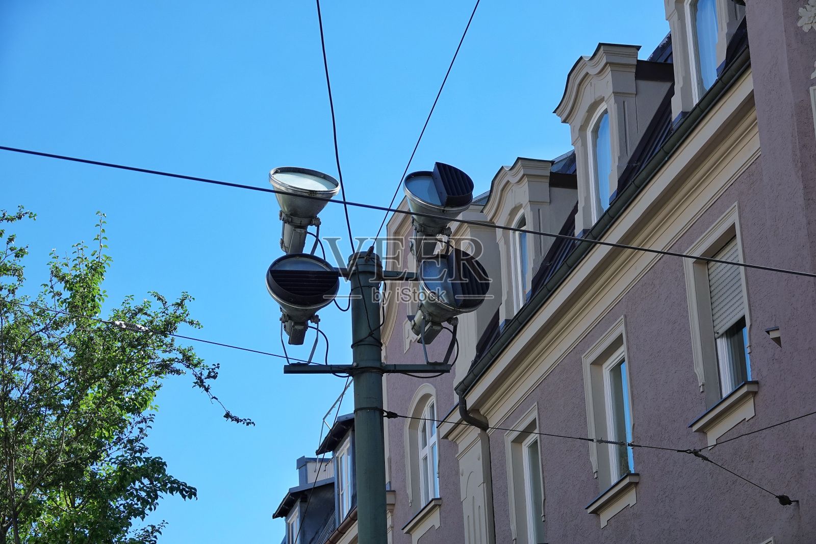 以建筑物和蓝天为背景的路灯和电线照片摄影图片
