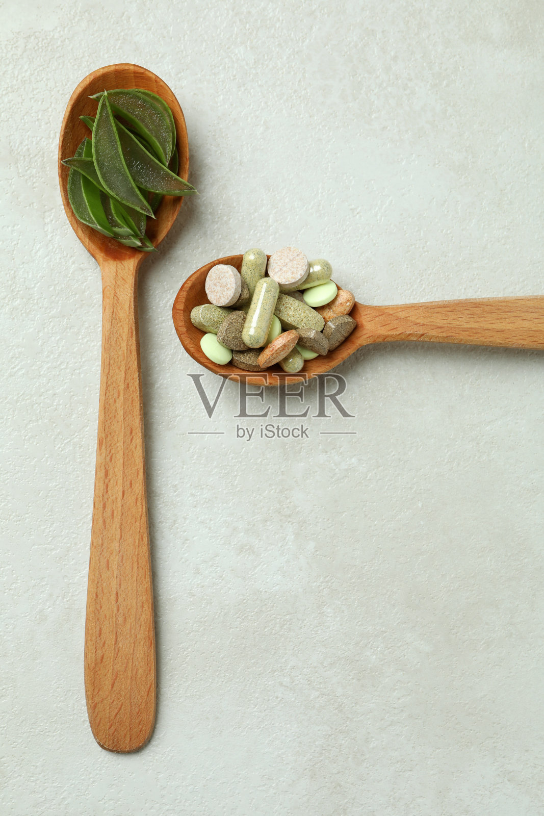 白色纹理背景上的芦荟片草药丸的概念照片摄影图片