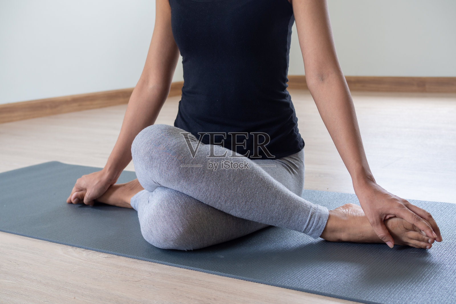 女性正在做坐姿扭转练习，以保持健康和强健的身体。瑜伽的概念照片摄影图片