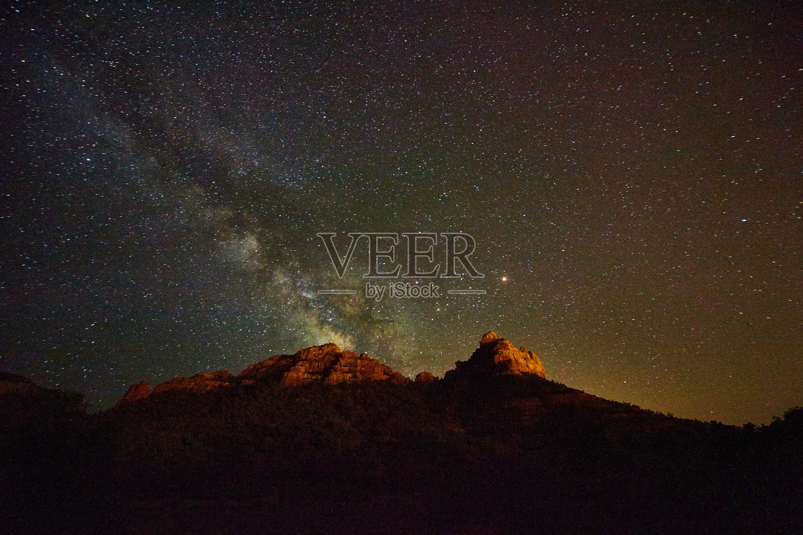 夜晚的银河在沙漠和红色的山脉照片摄影图片
