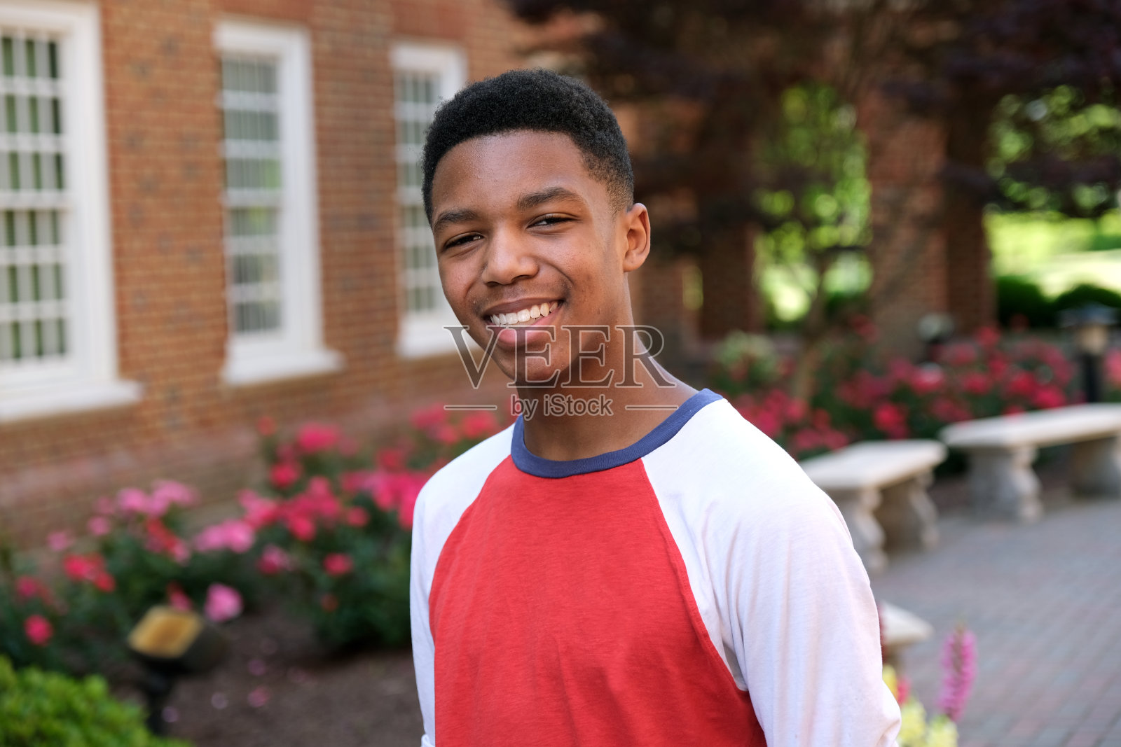 十几岁的男孩肖像户外与砖包围照片摄影图片