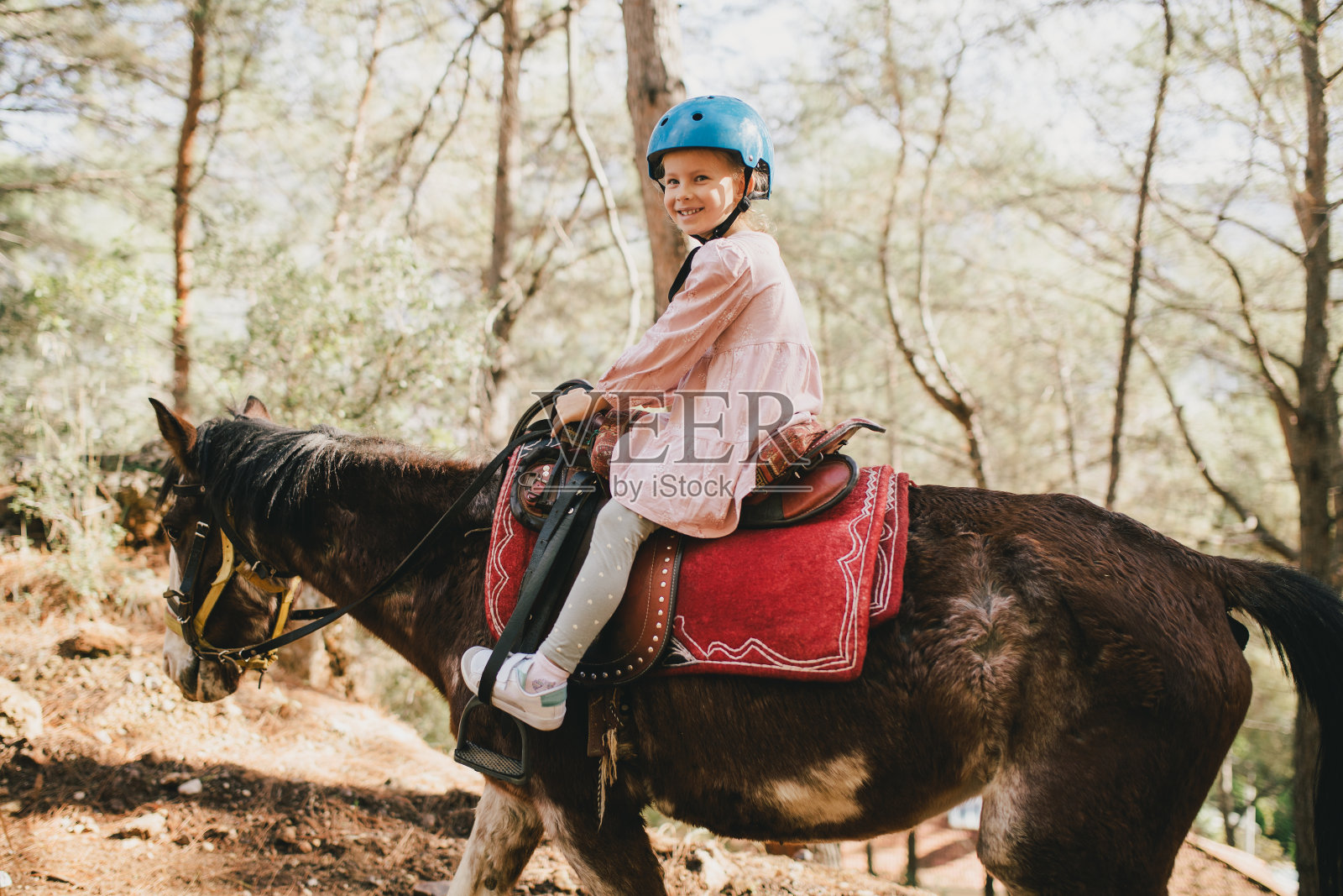 年轻的女孩骑着马穿过风景如画的地方。照片摄影图片