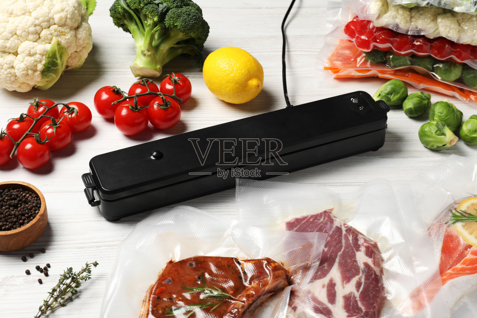 真空包装封口机，适用于各种食品，白色木桌照片摄影图片