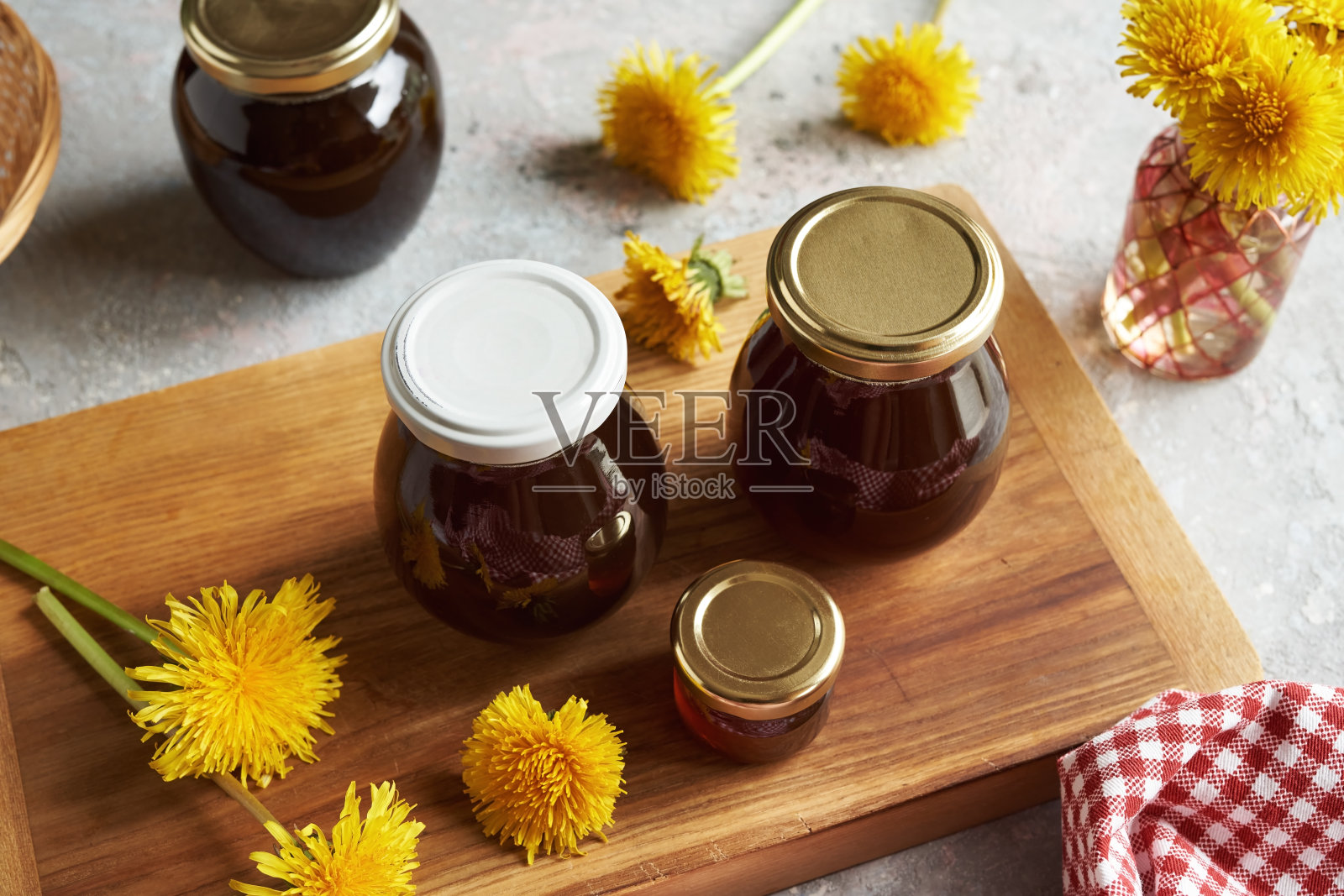 桌上放着几罐蒲公英蜂蜜和鲜花照片摄影图片