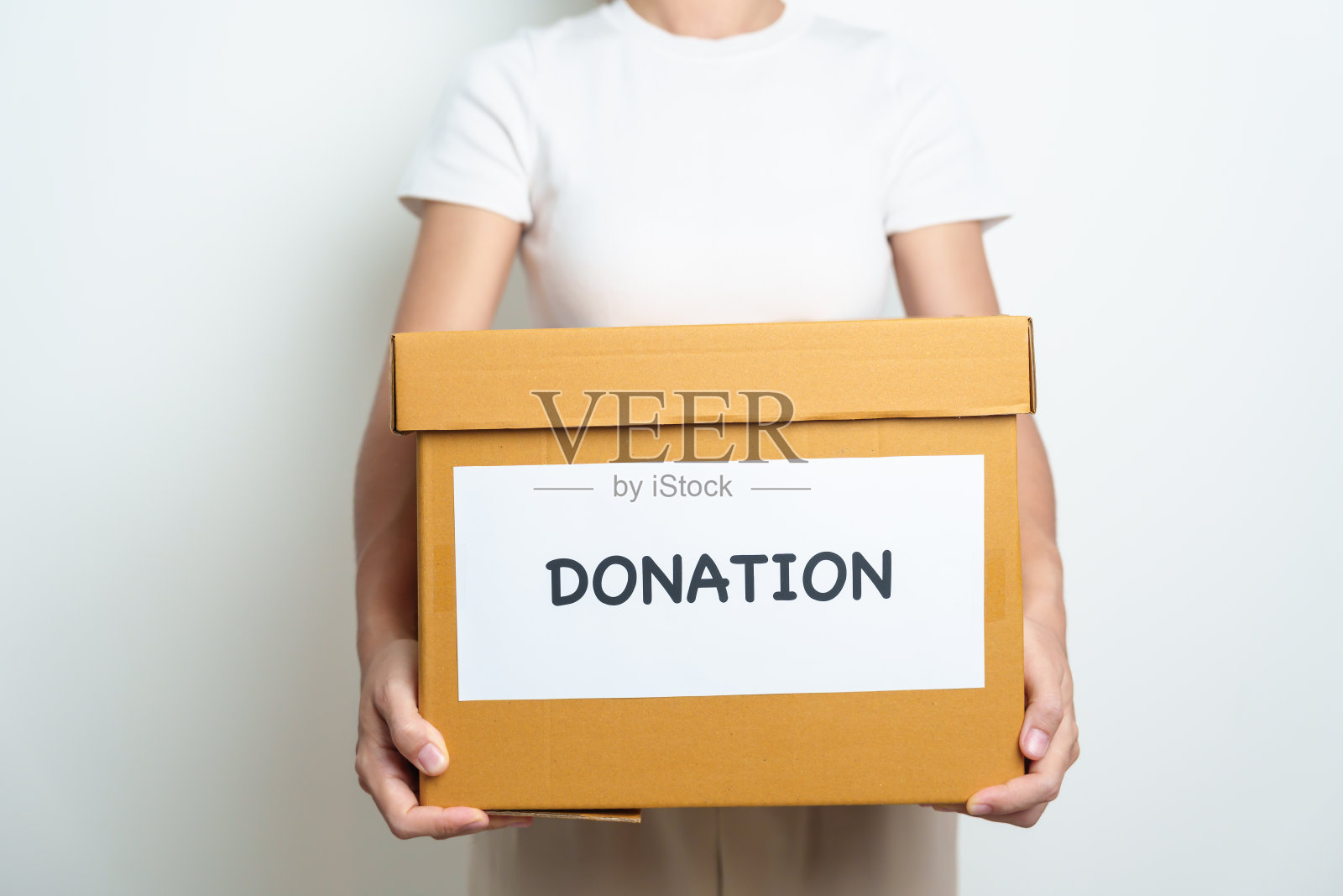 捐赠、慈善、志愿、给予、传递理念。人们把衣服和食物捐赠到家里或办公室的捐款箱里，以支持和帮助穷人、难民和无家可归的人。本空间照片摄影图片