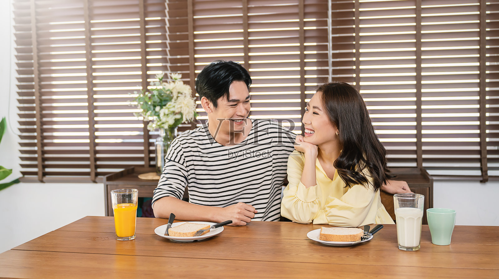 幸福的亚洲恩爱夫妇的肖像享受在咖啡厅酒店或餐桌上吃早餐。现代家庭爱约会健康饮食生活方式假期，刚结婚蜜月期概念照片摄影图片