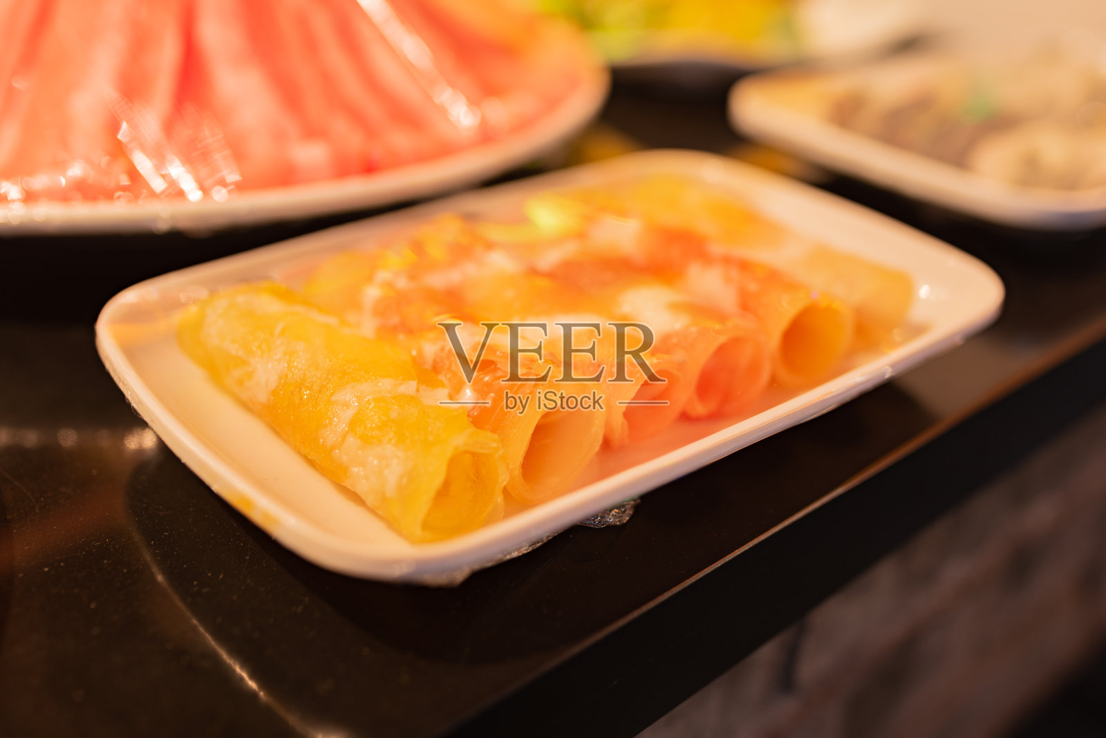 橙肉卷装在盘子里照片摄影图片