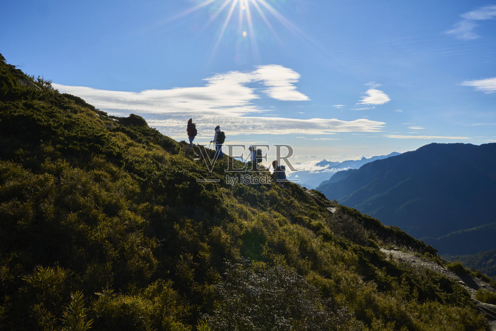 女徒步者独自走在山顶上的剪影。照片摄影图片