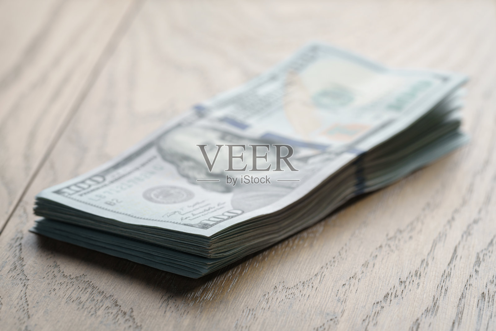 橡木桌上放着一堆钱照片摄影图片