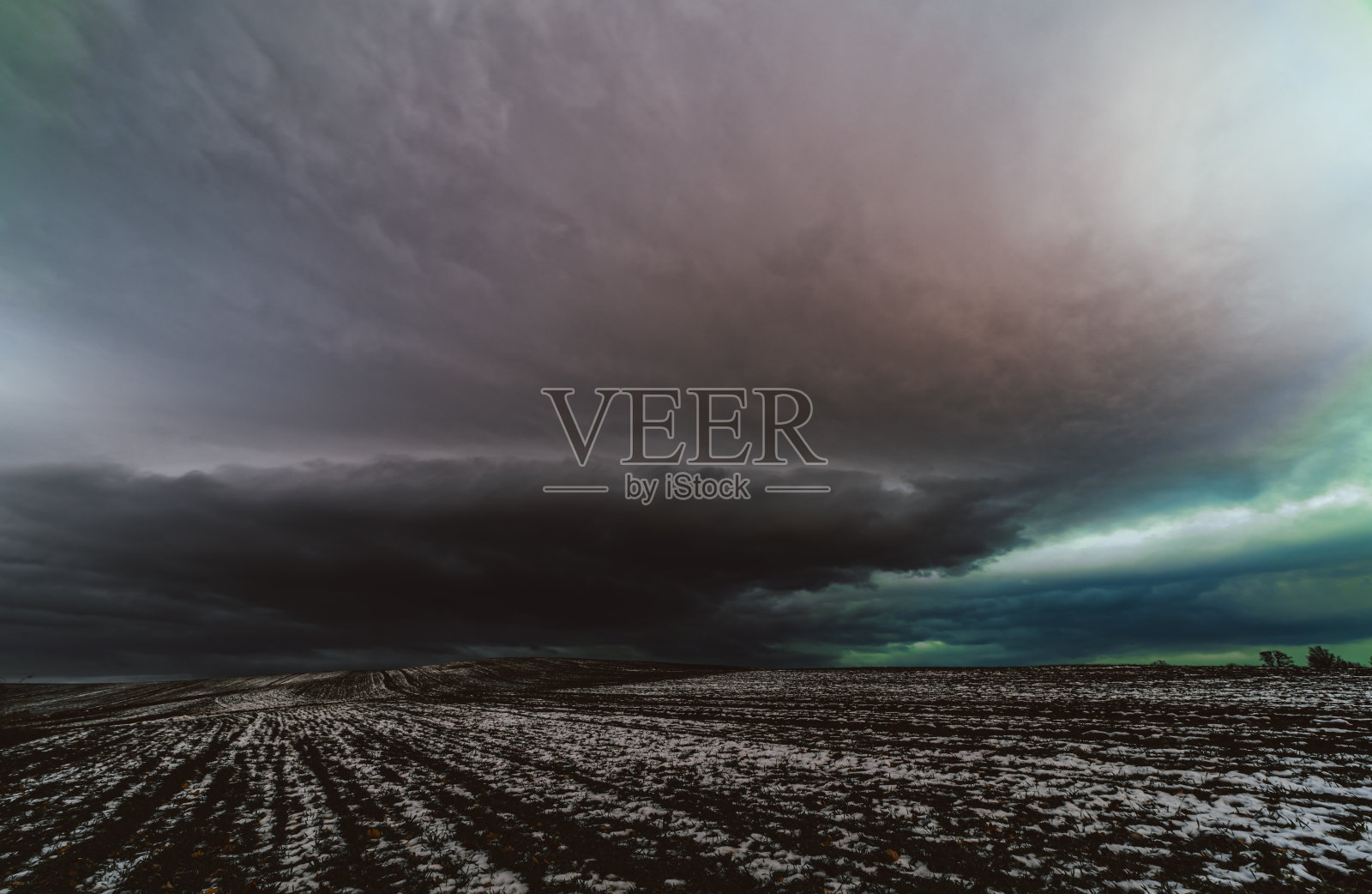 冬天的田野，背景是多云的天空照片摄影图片