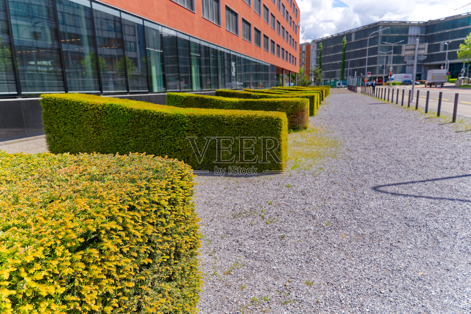 瑞士小镇的现代办公大楼立面的缩小视图与树篱。照片摄影图片