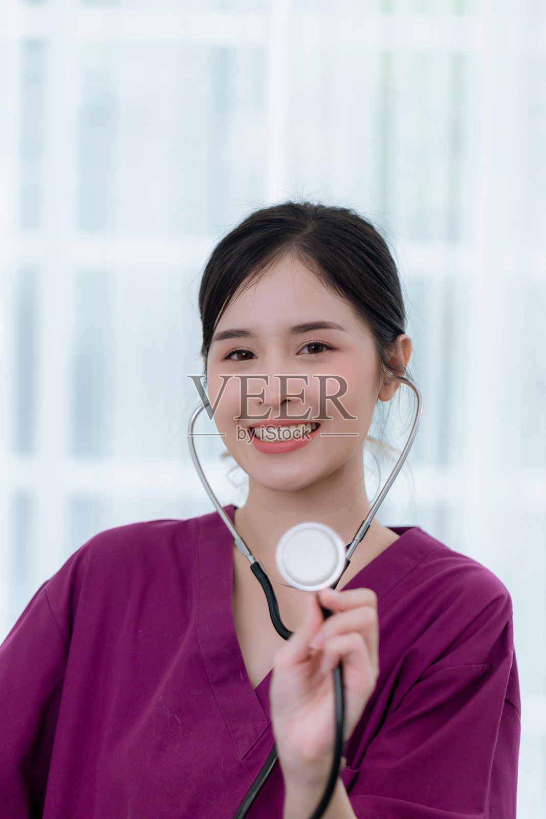 妇女保健工作者的肖像。女药剂师带着听诊器在养老院工作。照片摄影图片