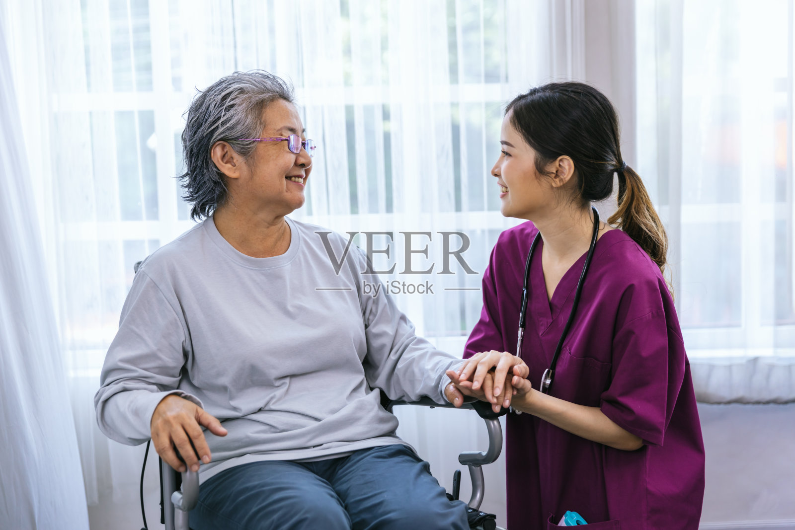 护理员照顾一位在公园散步的老年病人。护士帮助老年妇女照片摄影图片