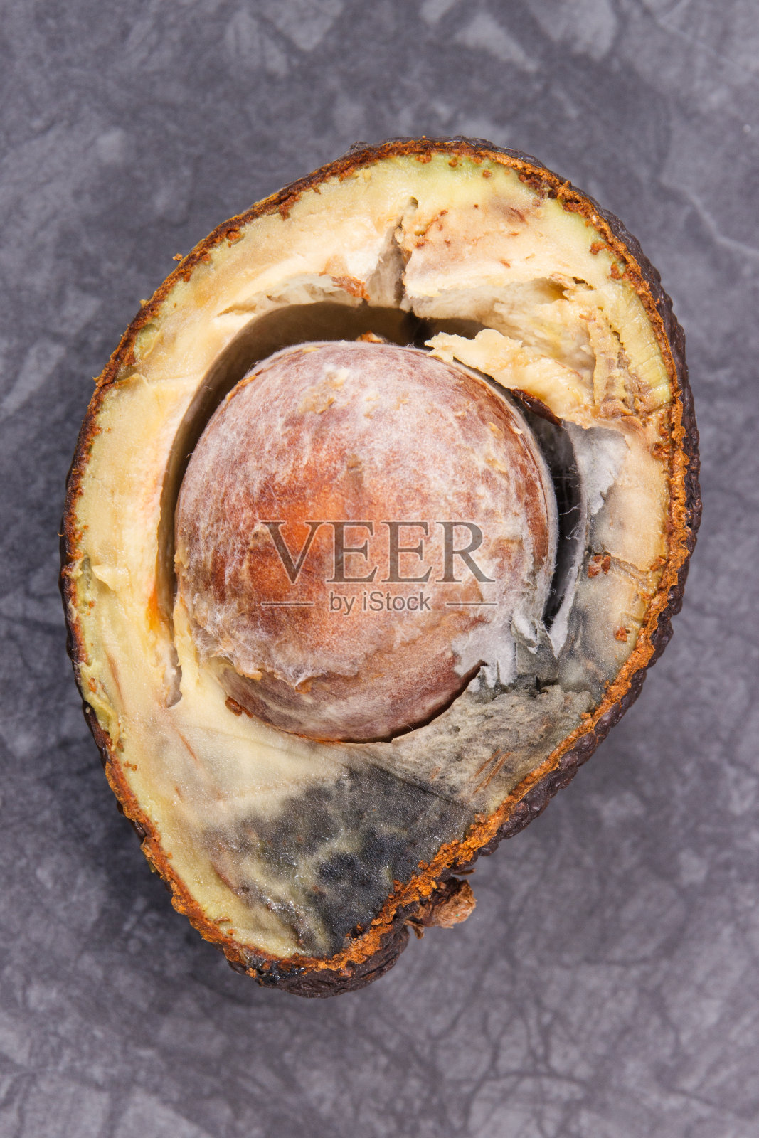 长霉的牛油果不可食用。黑暗的背景。不健康的食物照片摄影图片