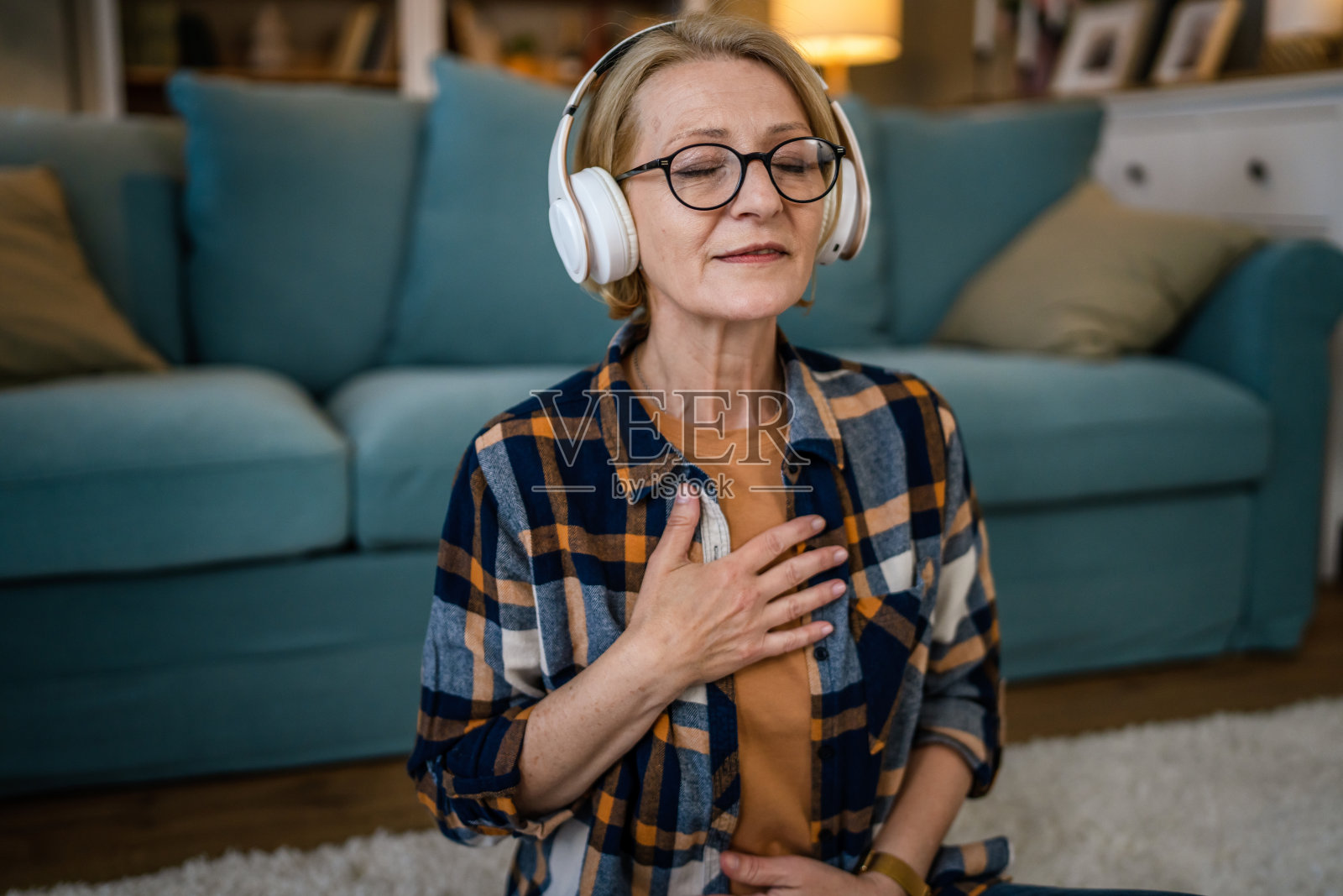 成熟的老年妇女在家练习引导冥想的表现照片摄影图片