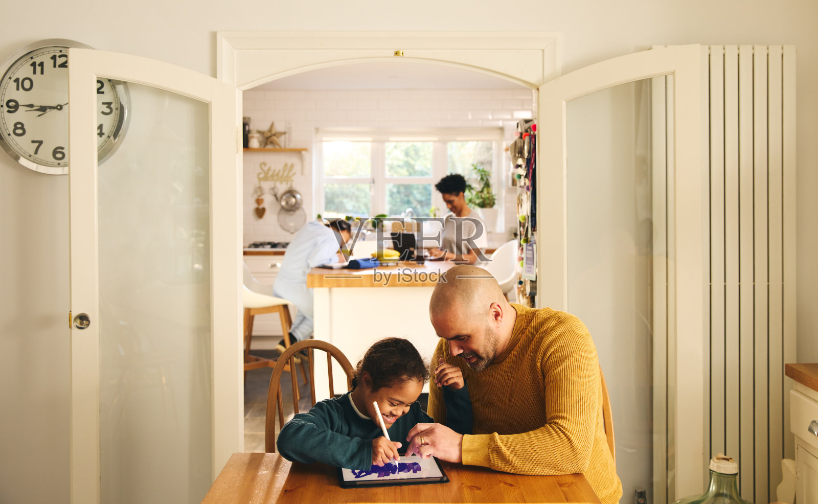 多民族家庭：父亲和患有唐氏综合征的儿子在家使用平板电脑照片摄影图片