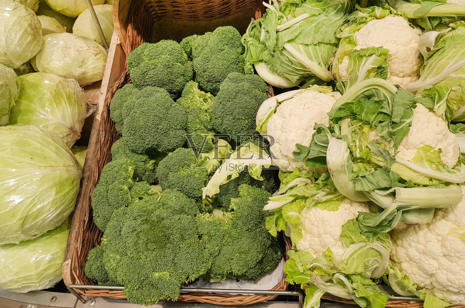 近距离展示新鲜的白卷心菜，花椰菜，花椰菜在柳条篮子，背景蔬菜在市场上照片摄影图片