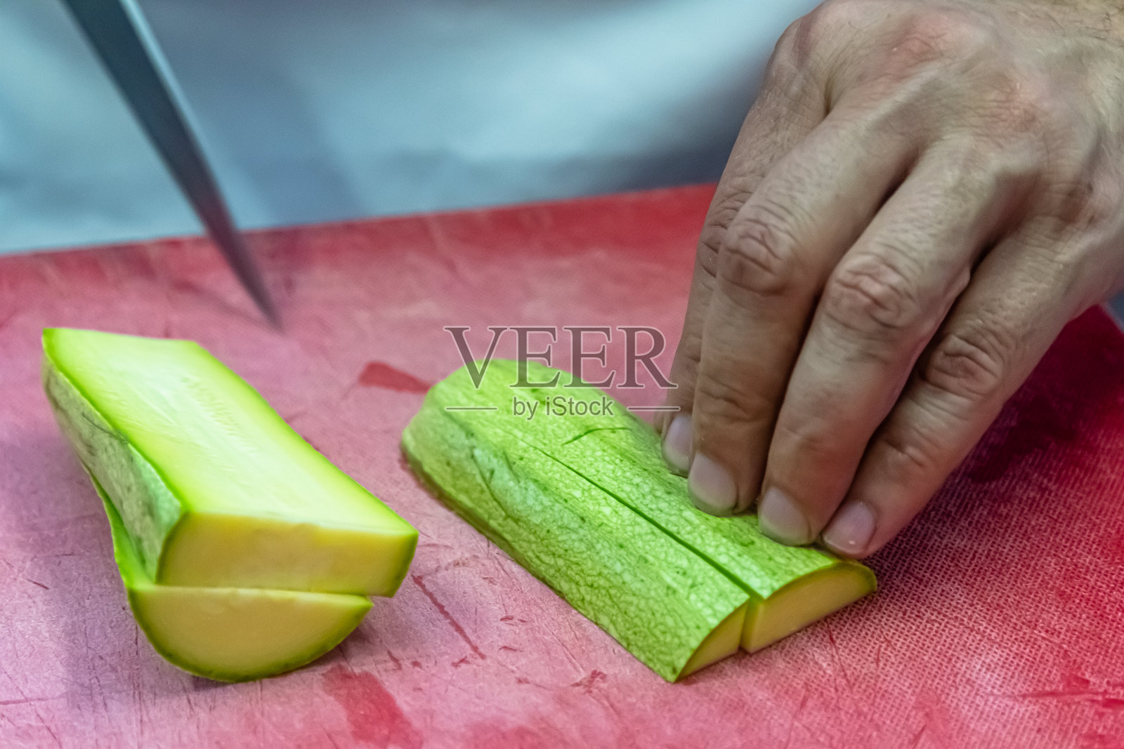 在红色砧板上切西葫芦照片摄影图片