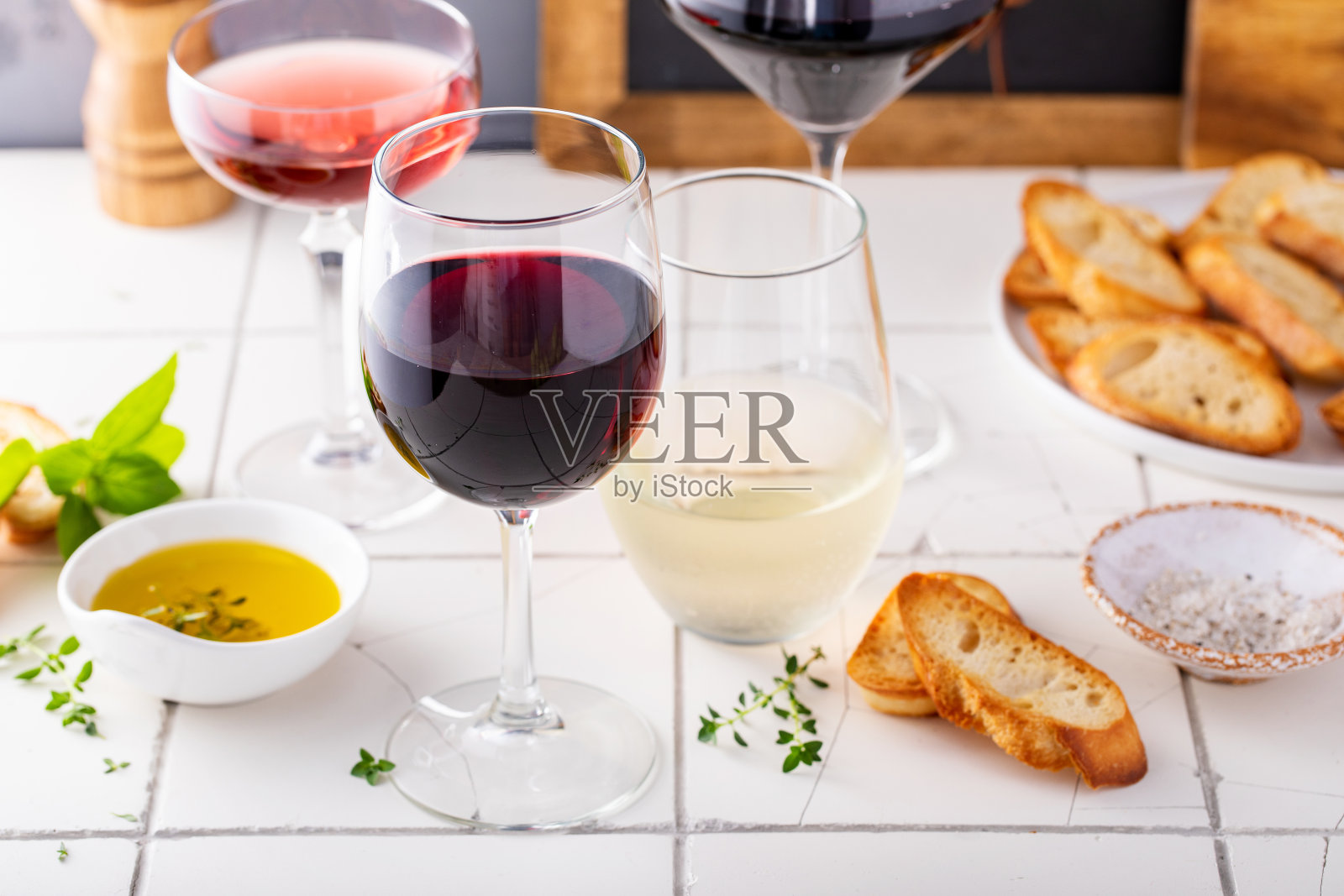 各种葡萄在不同的玻璃杯与橄榄油和法棍面包照片摄影图片