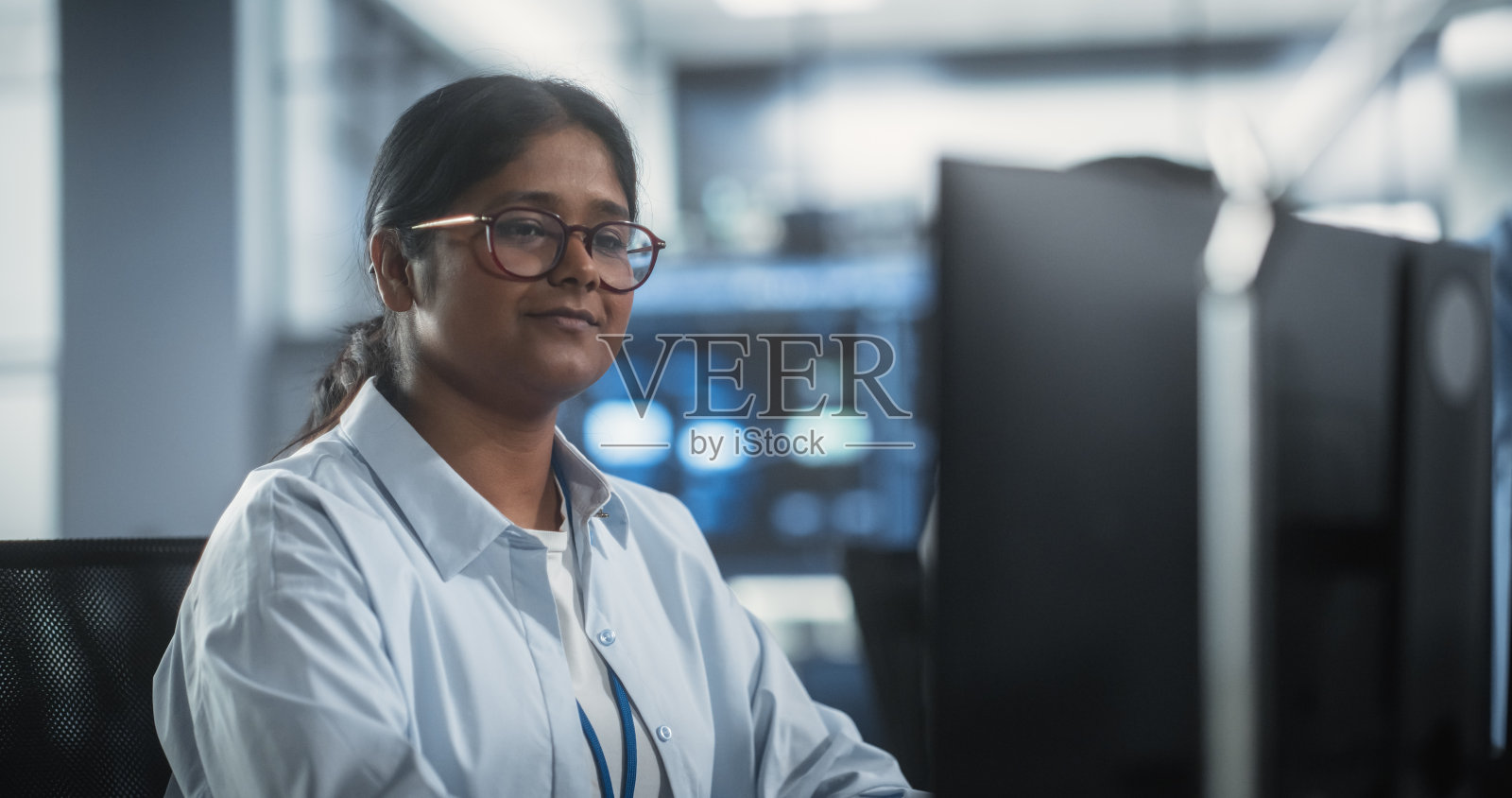 一个聪明专注的南亚工程师在一家科技公司的办公室里工作。为一家创新的互联网服务提供商开发软件的年轻女子照片摄影图片