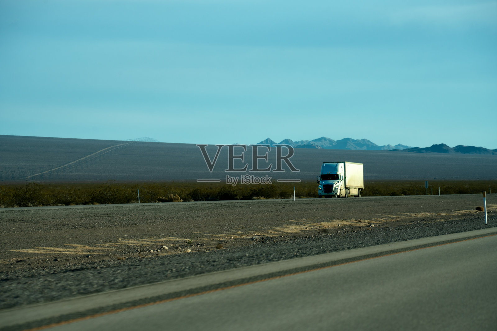 一辆白色半挂车在两车道公路上运输石油，天空中有美丽的云照片摄影图片