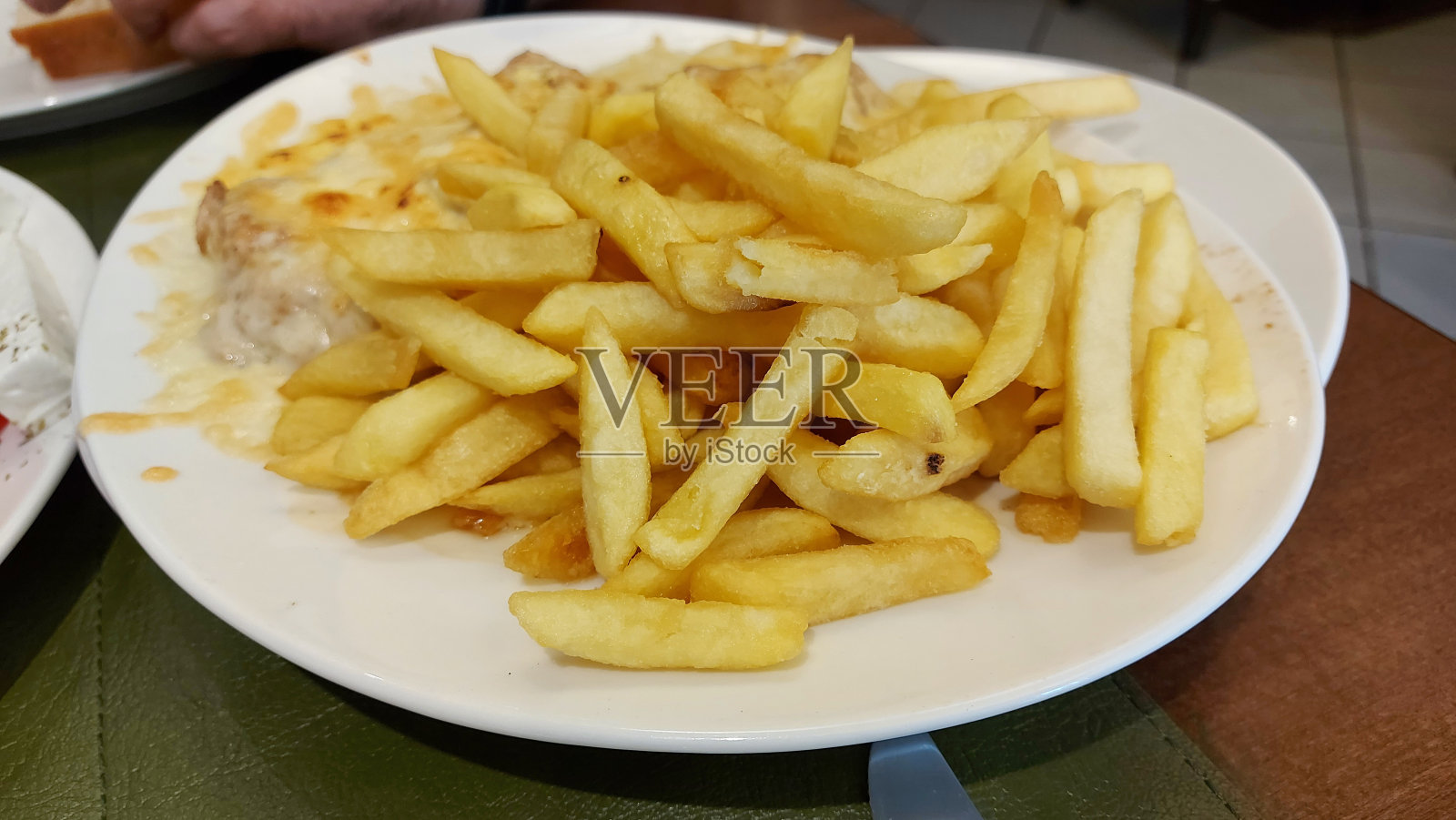 餐馆里餐桌上白色盘子里的薯条。健康食品。照片摄影图片