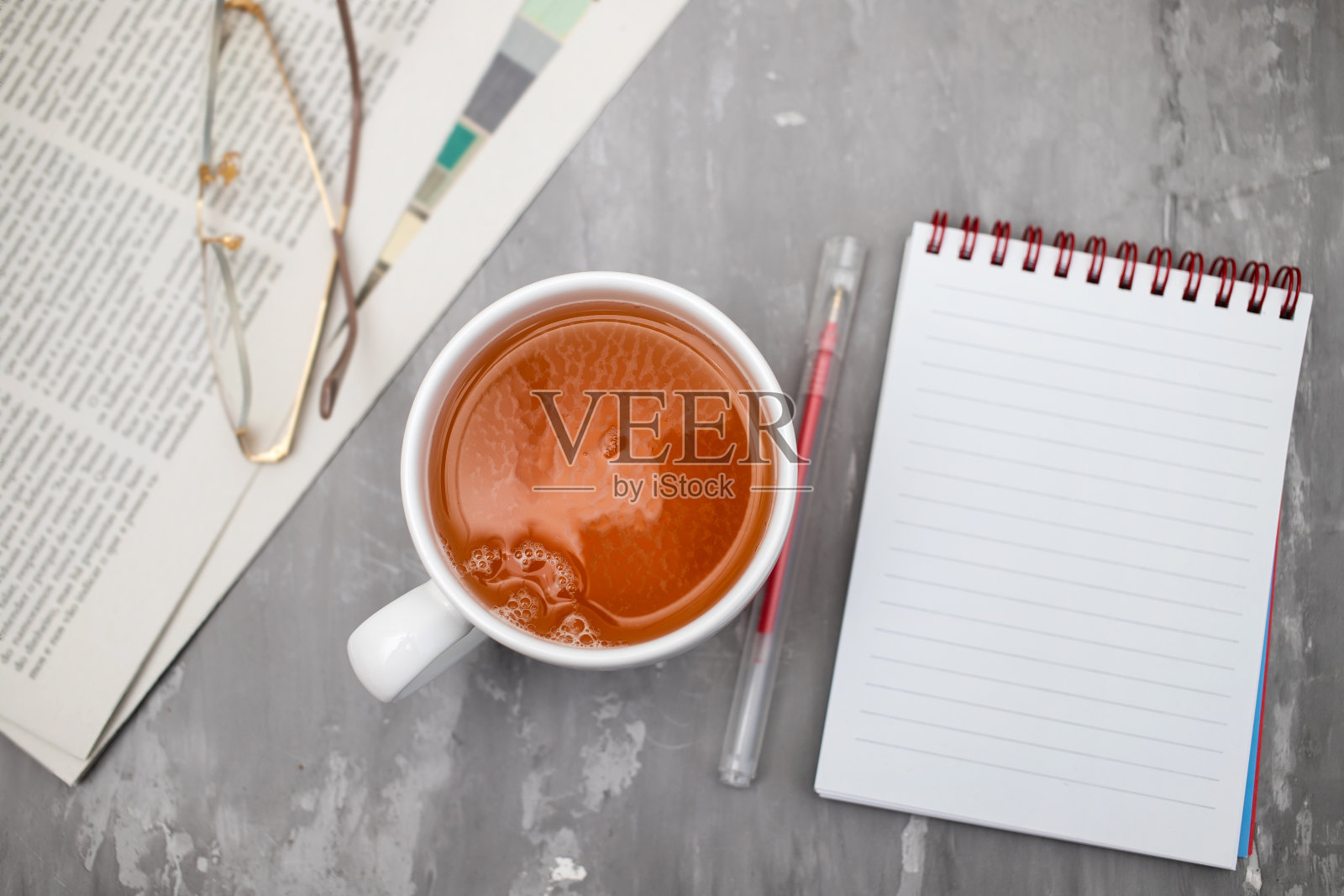 报纸和茶杯，配老花镜。照片摄影图片