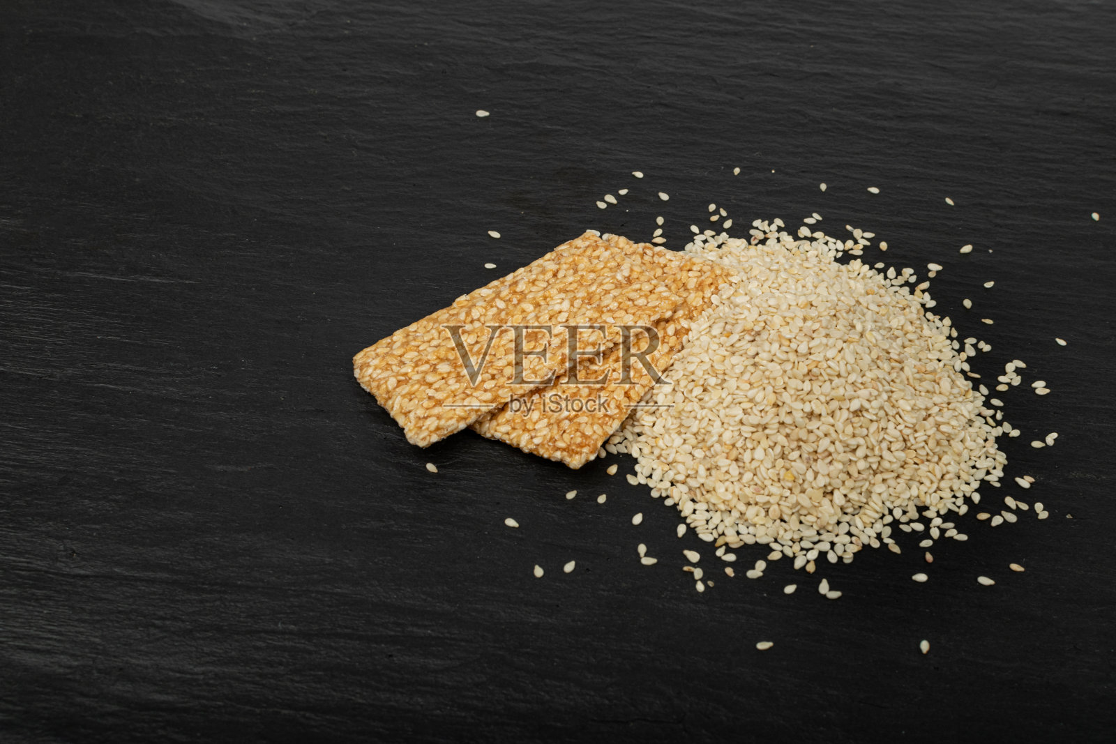 芝麻小吃，蜂蜜种子饼干，黑底芝麻糖果棒照片摄影图片