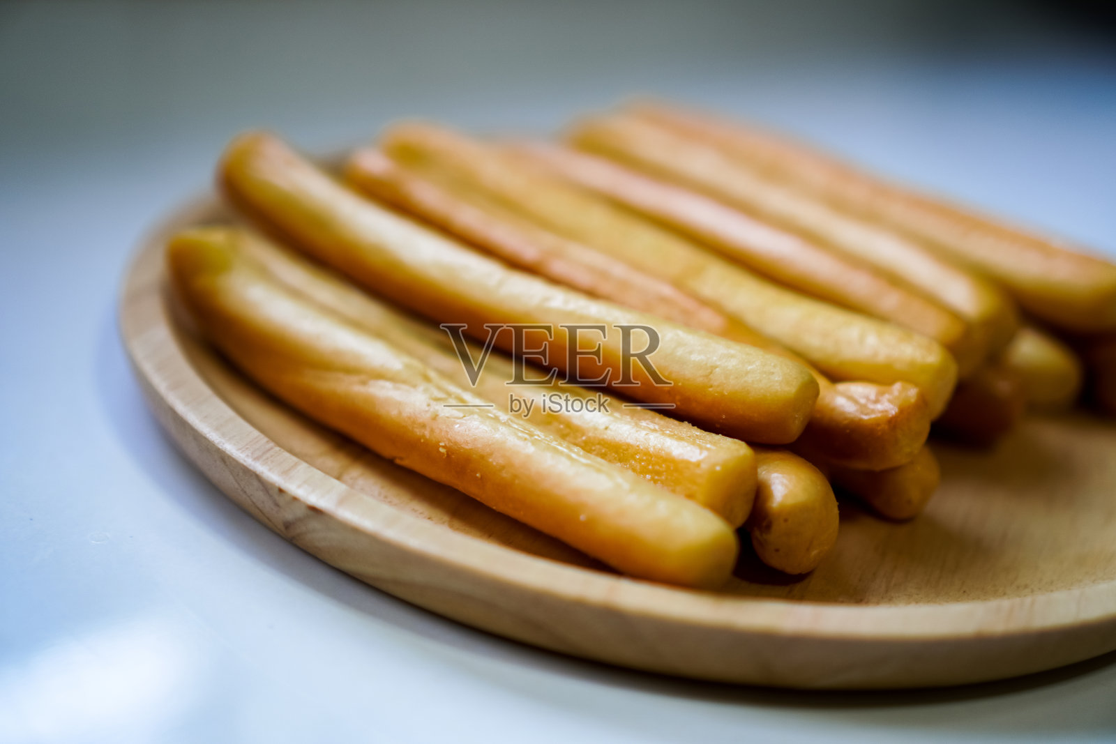 图为一根腌面包棒放在一个即食的木制盘子上。照片摄影图片