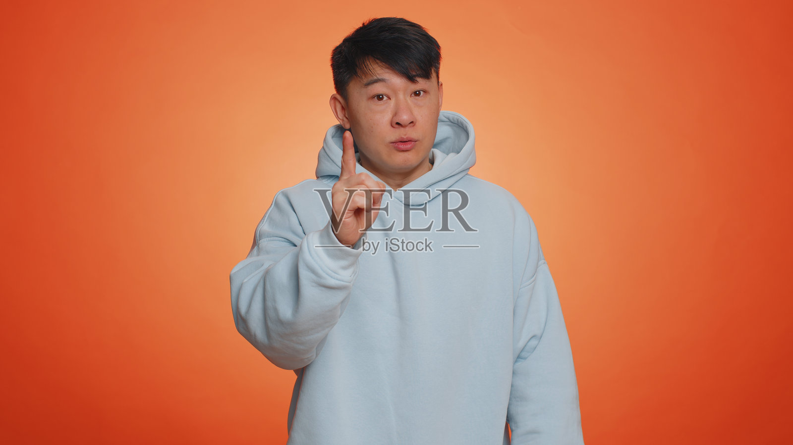 亚洲帅哥摇着手指说不，小心，避免危险的错误，不赞成的迹象照片摄影图片