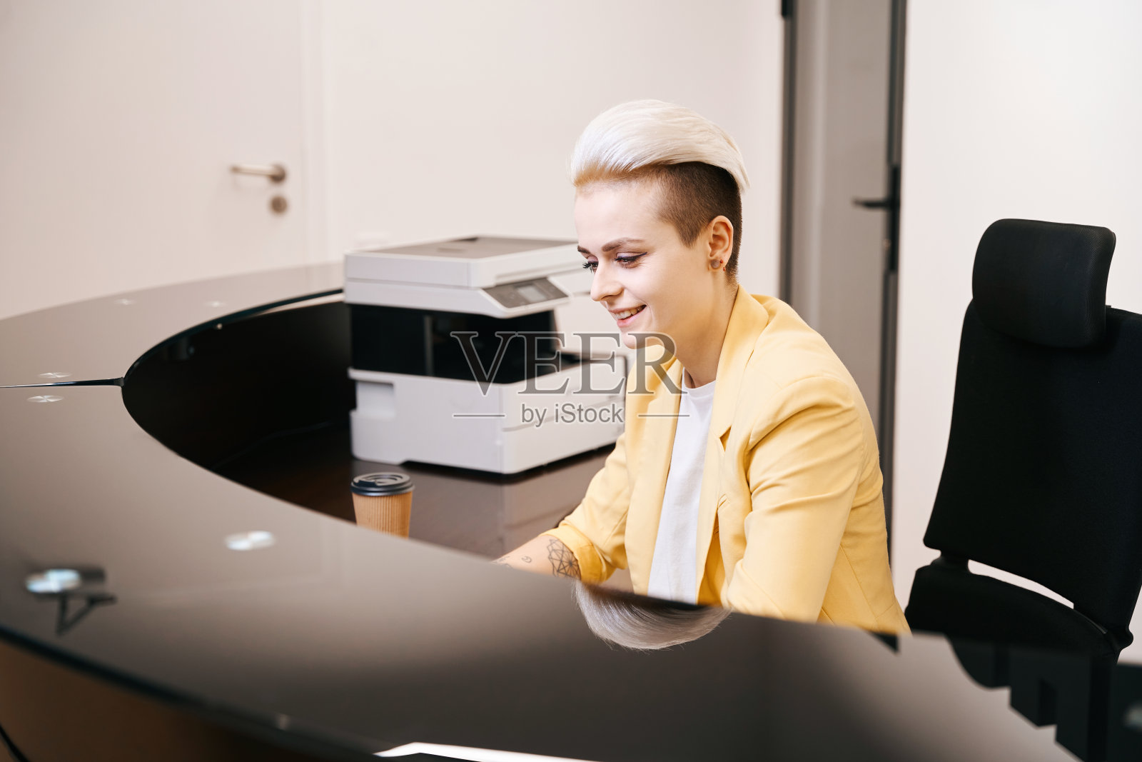 微笑的女人坐在柜台前工作照片摄影图片