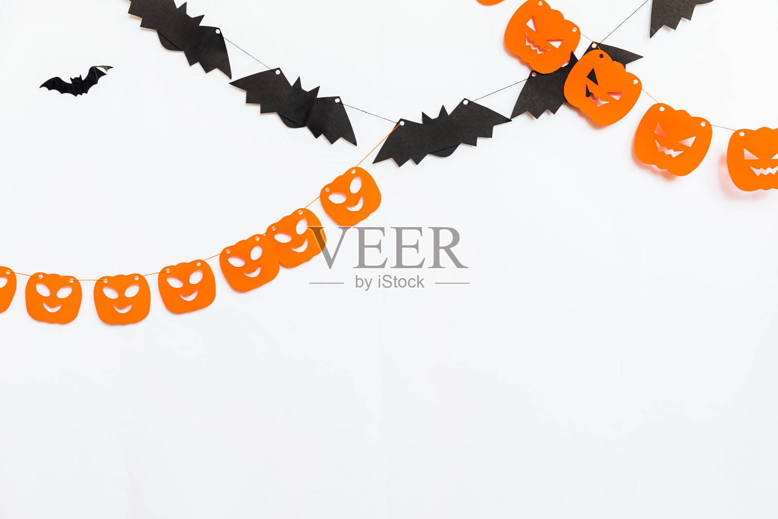 不给糖就捣蛋的概念。节日构图与万圣节花环装饰南瓜和蝙蝠孤立在白色背景。为万圣节派对做准备。秋天秋天万圣节快乐照片摄影图片