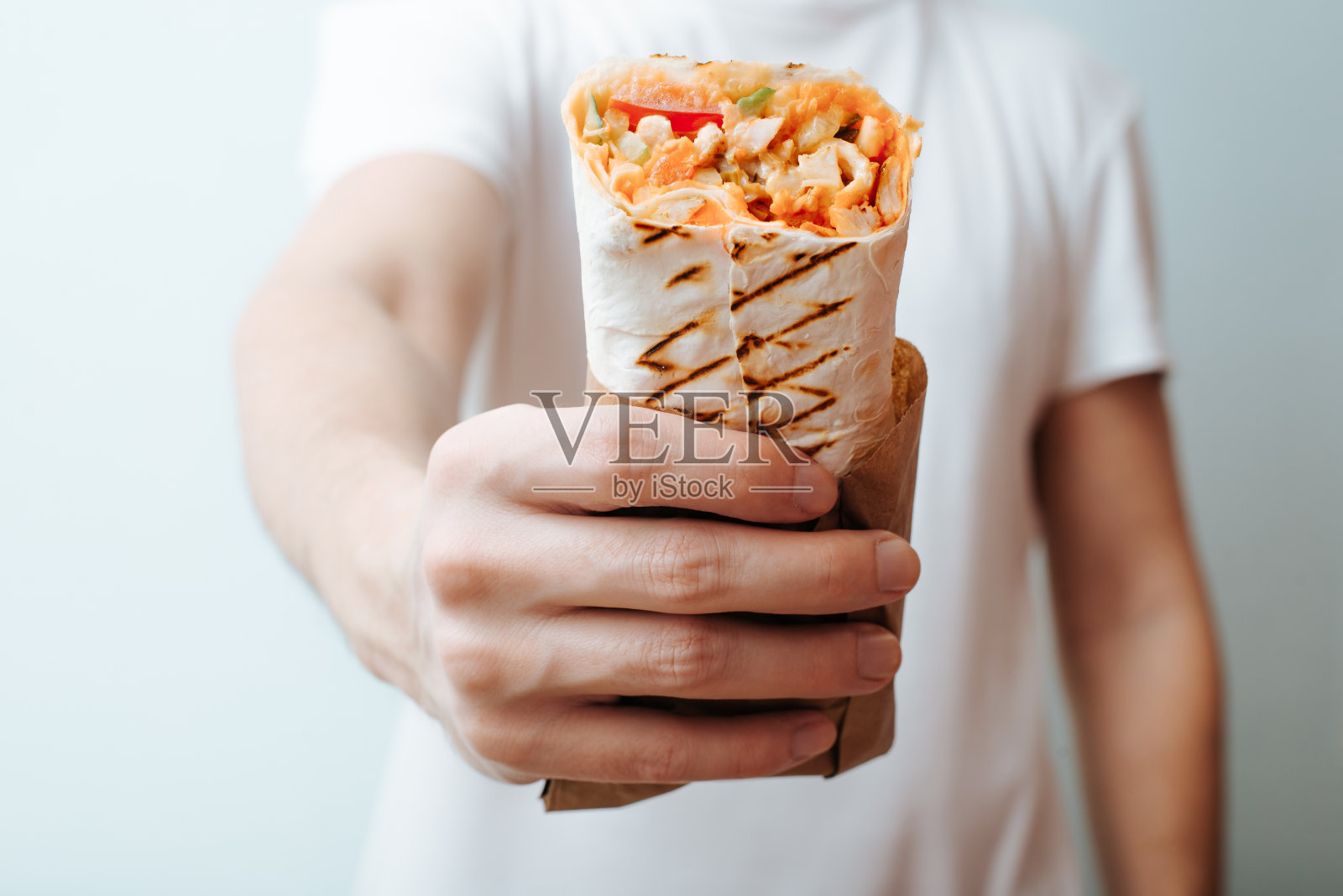 特写的不认识的人展示沙瓦玛，烤肉串或馅饼面包。快餐广告照片摄影图片